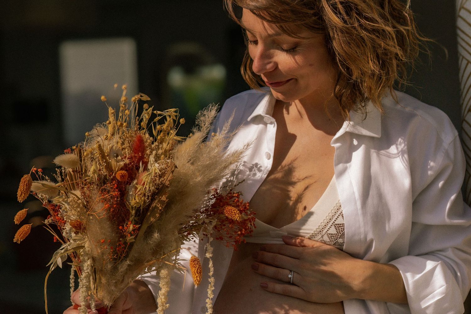 photographe grossesse à domicile avec ombre et lumière et fleurs séchées à Marseille