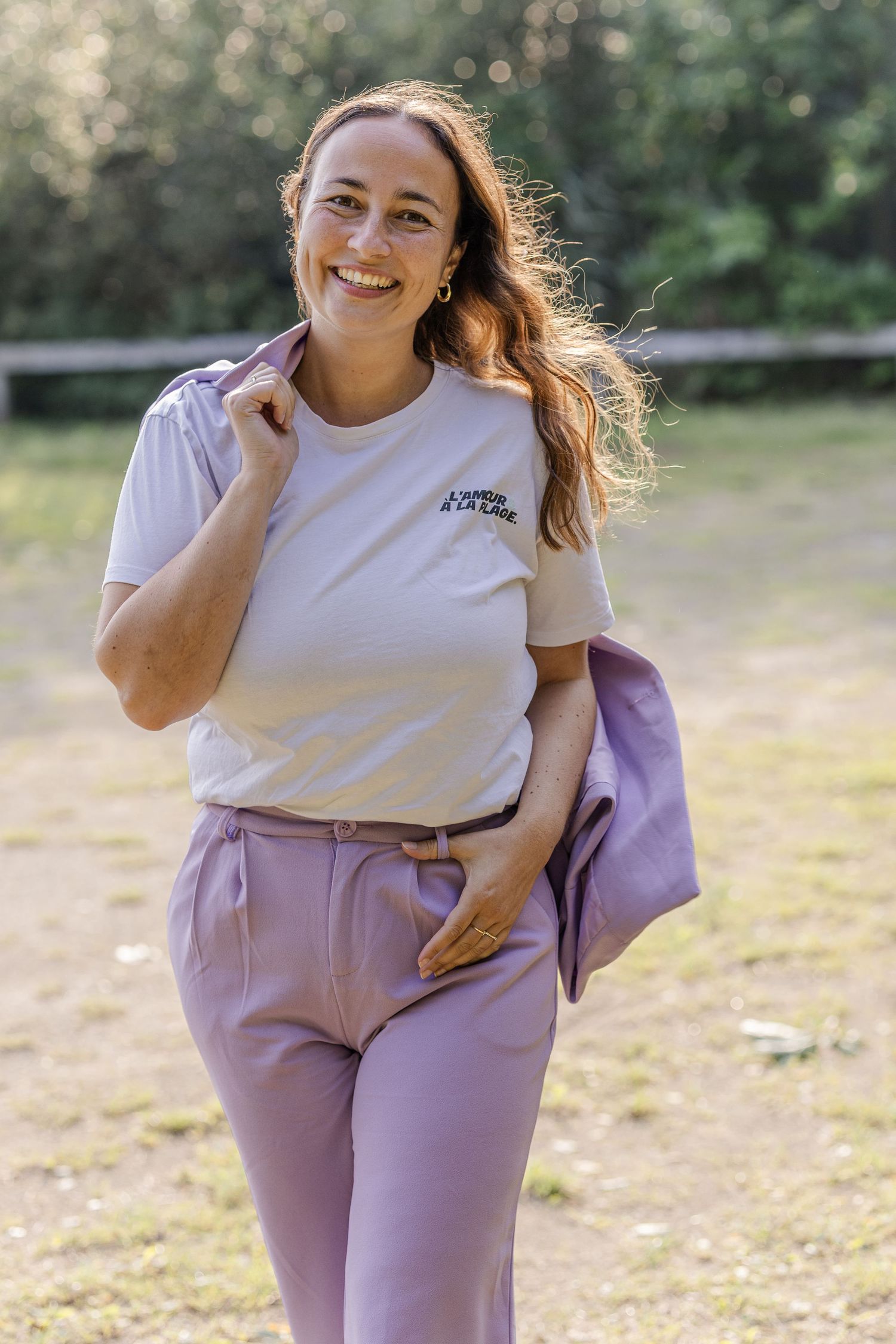 Laughing woman I a purple suit walks towards the photographer and smiles