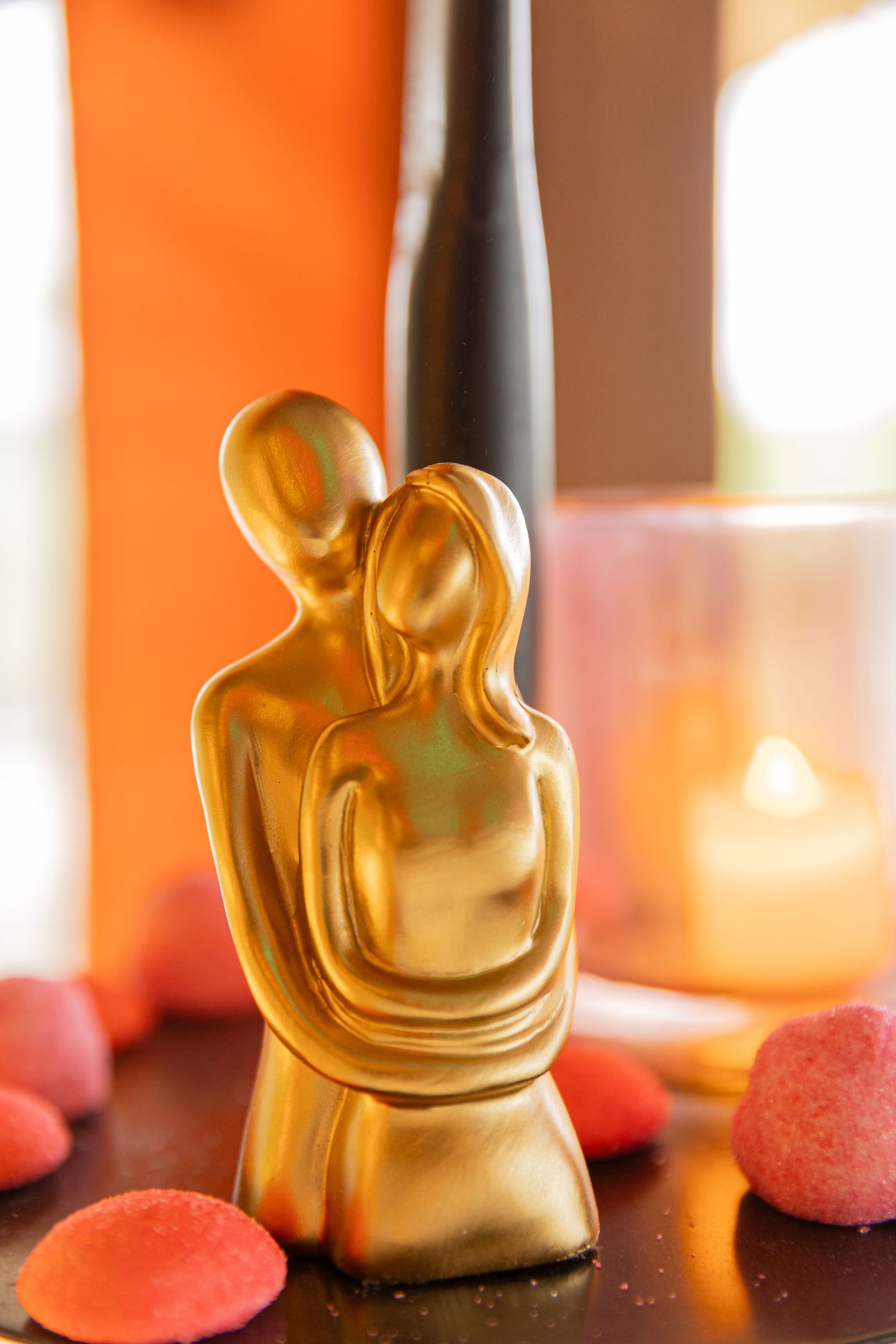 A beautiful gold statue depicting two people embracing each other captured at a wedding ceremony