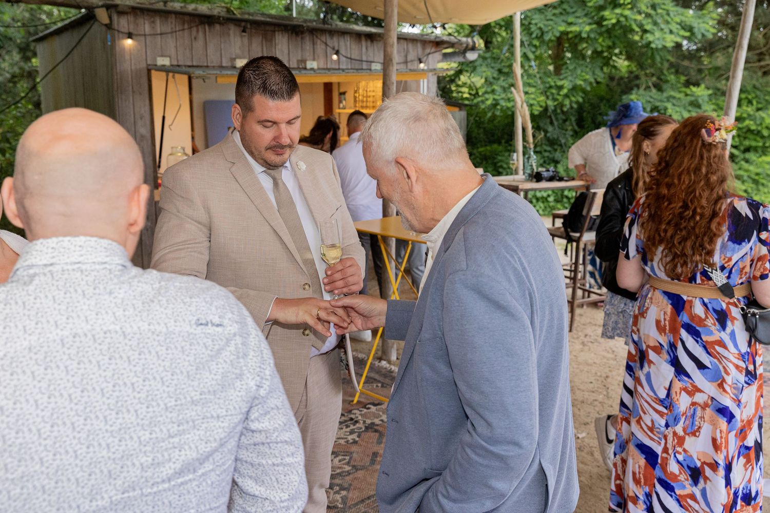 Father of the groom looking at the ring on the finger of his son
