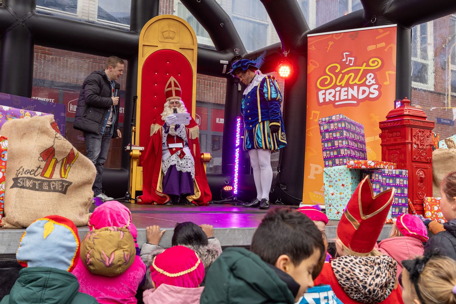 Sinterklaas and Piet are on stage, where the children are happy to see them