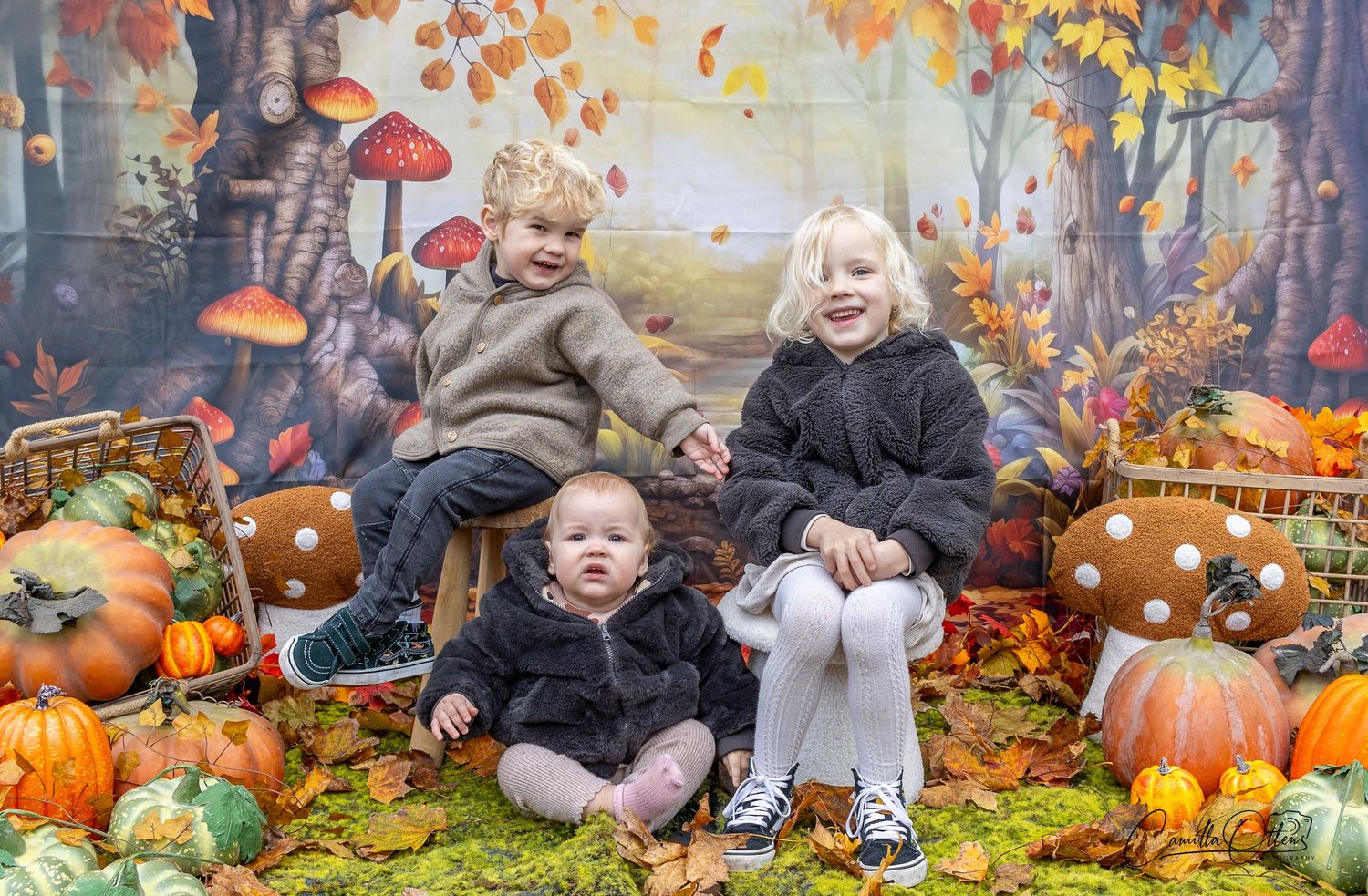 Three children enjoying the autumn vibes in a photography stand