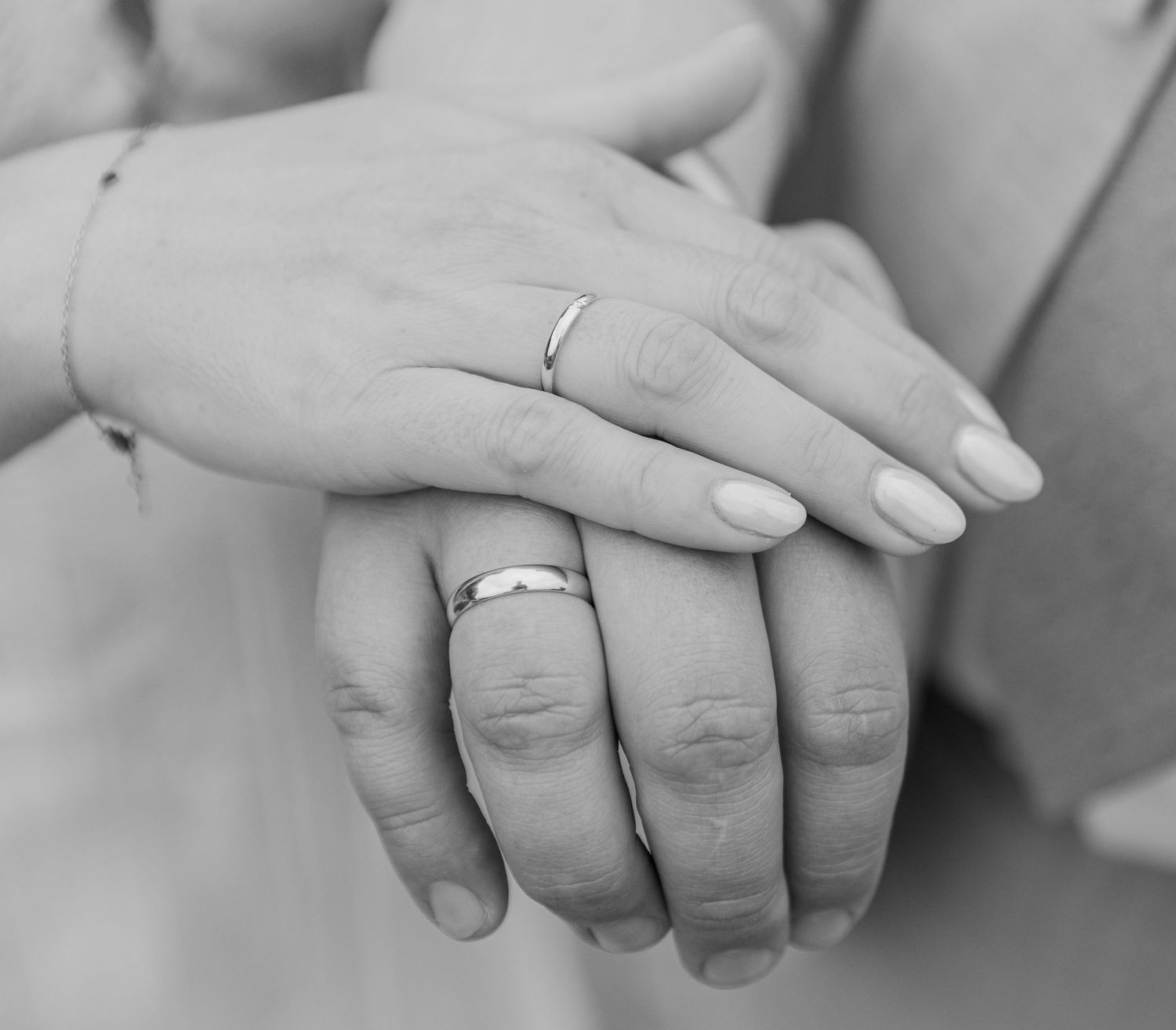 Hands from the bride and groom together with the rings during their wedding