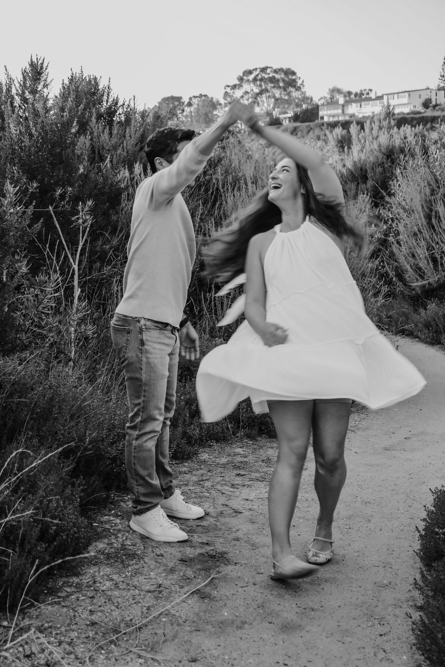 Low angle black and white photo of couple walking along outdoor path.