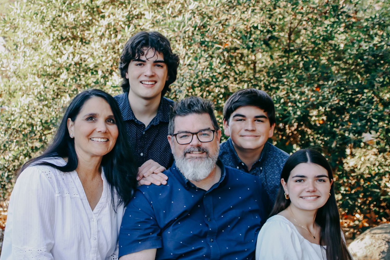 Casual outdoor family photoshoot showing close-up expressions and smiles.