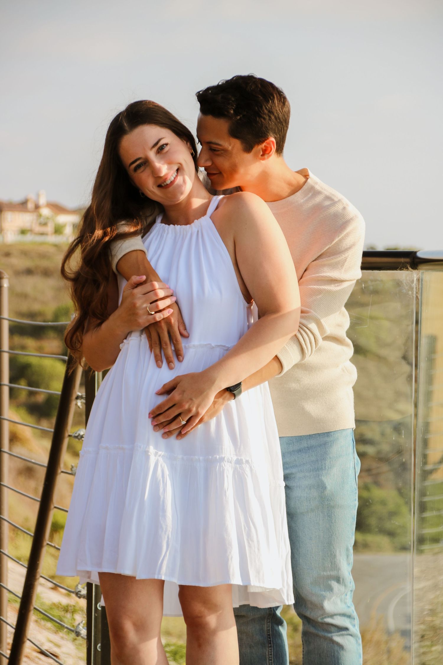 Loving couple embracing on outdoor deck with desert scenery in background.
