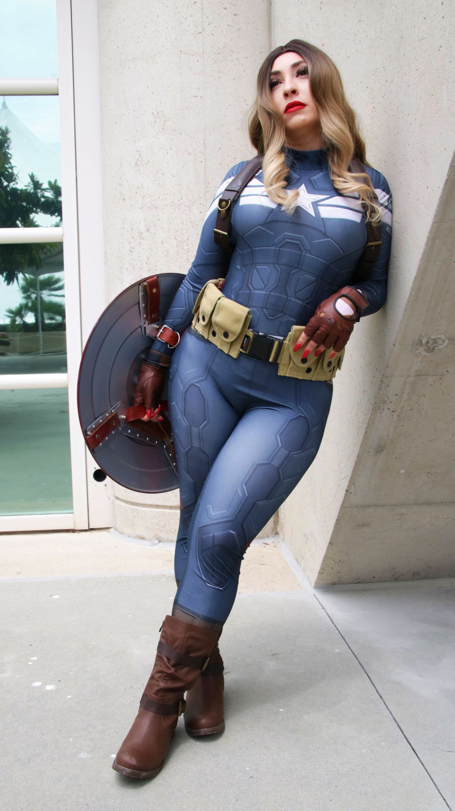 Cosplayer wearing a Captain America inspired costume with shield and tactical gear.
