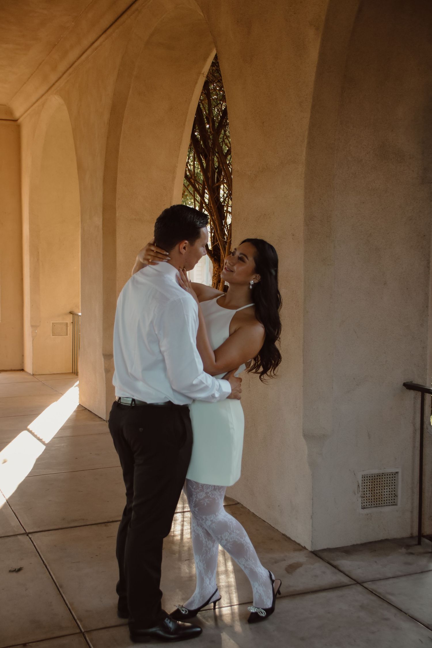 A romantic dance sequence captured in warm lighting under architectural arches.
