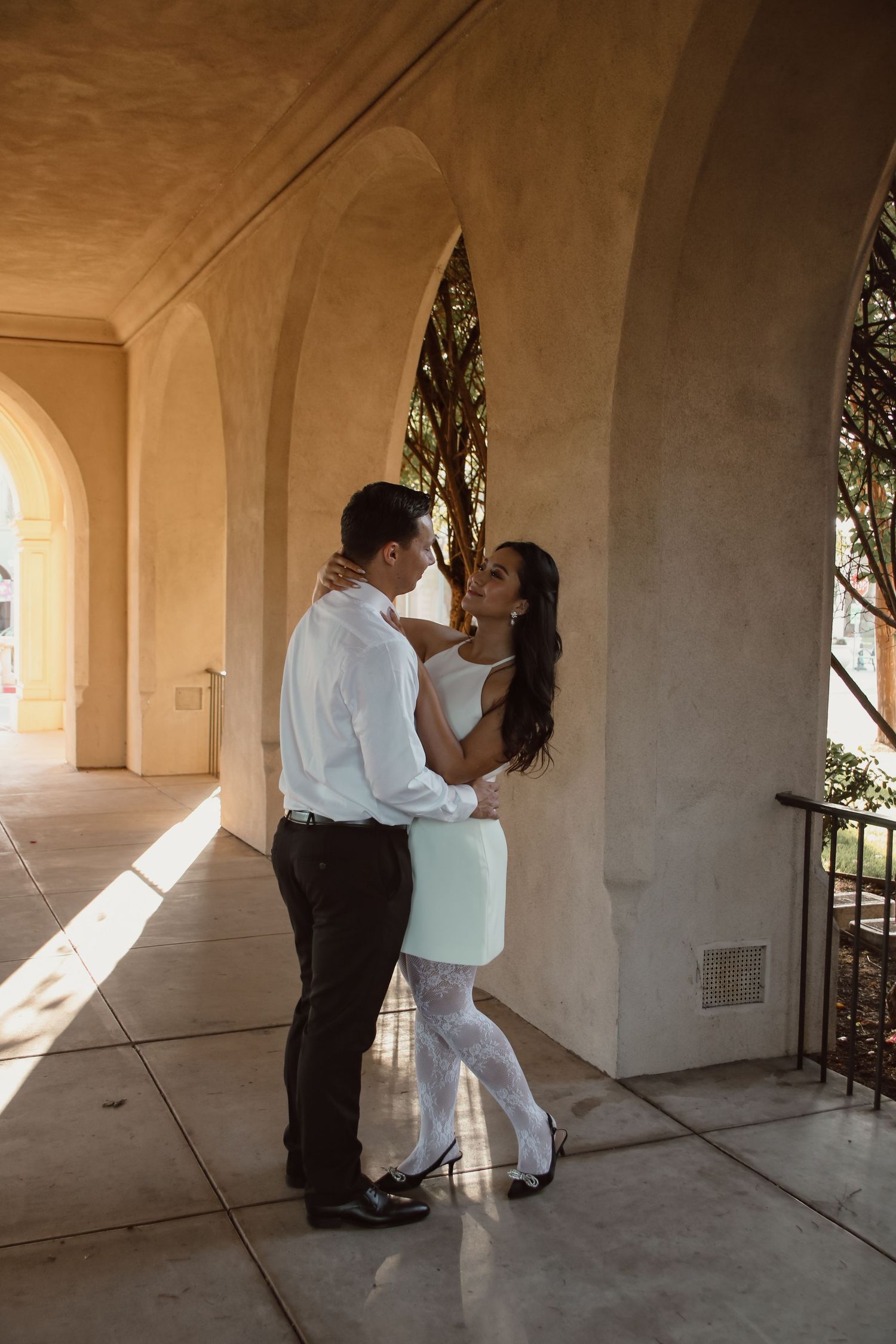 Artistic shots of a couple dancing in an outdoor colonnade with dramatic lighting.