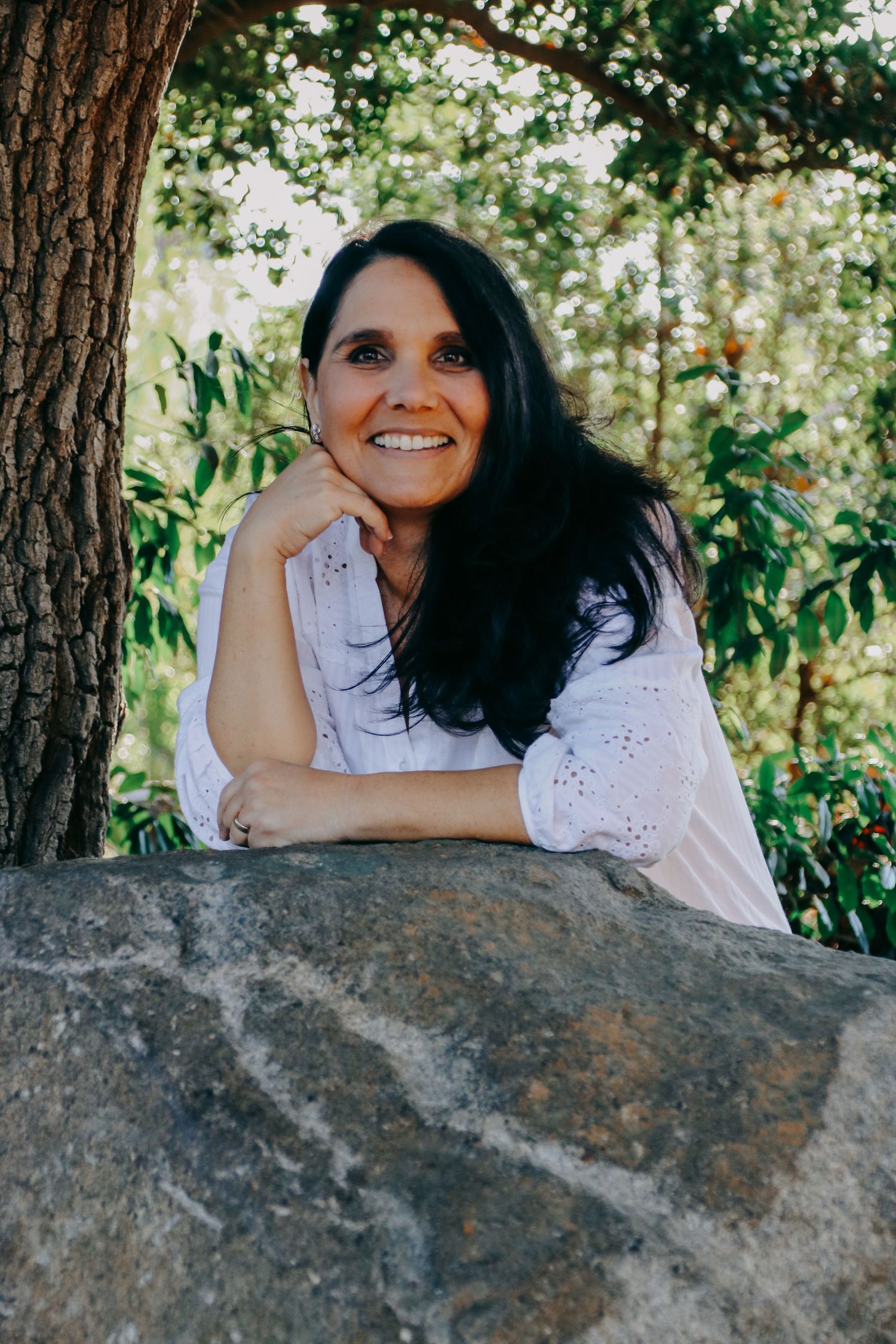 Series of portraits showing a person resting on a rock in a sunlit forest setting.