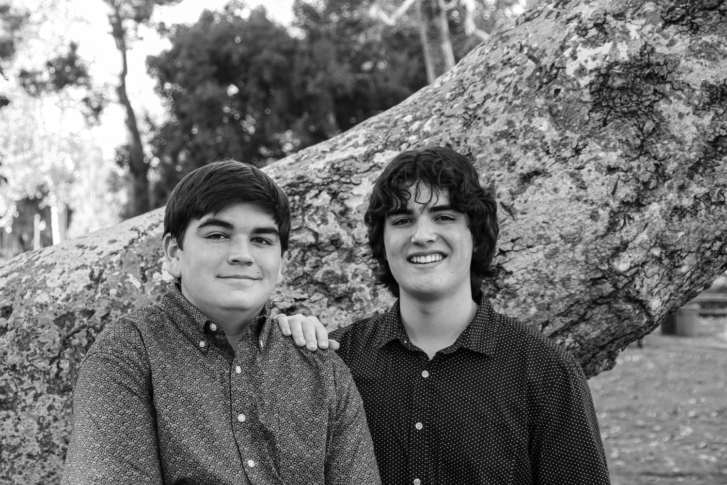 Black and white portraits showing genuine smiles and natural interaction outdoors.