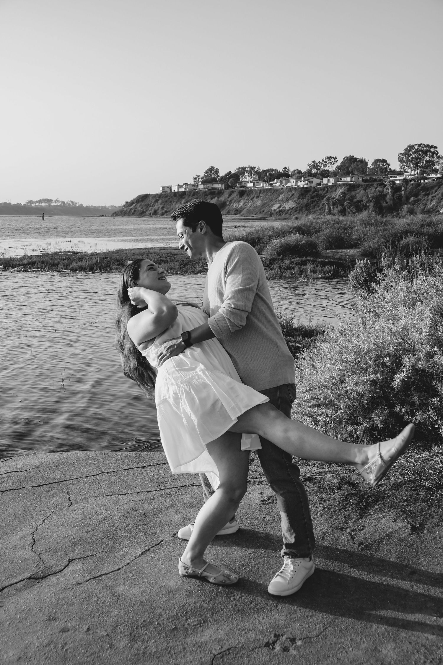 Black and white coastal photo of dancing couple in casual attire.