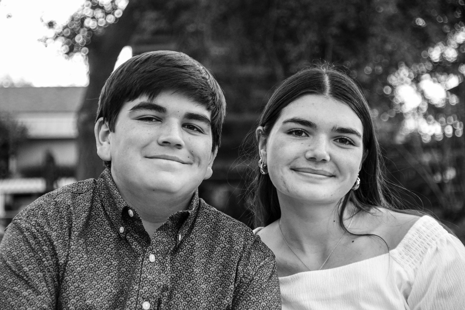 Close-up black and white portrait captures genuine smiles and warmth between two people.