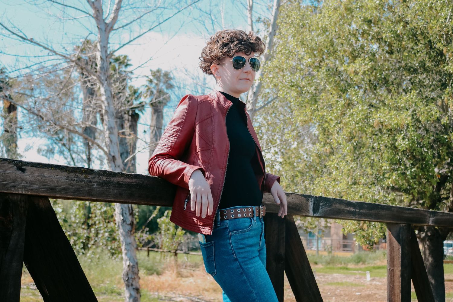 Spring fashion photography on wooden railroad bridge with bright natural lighting.