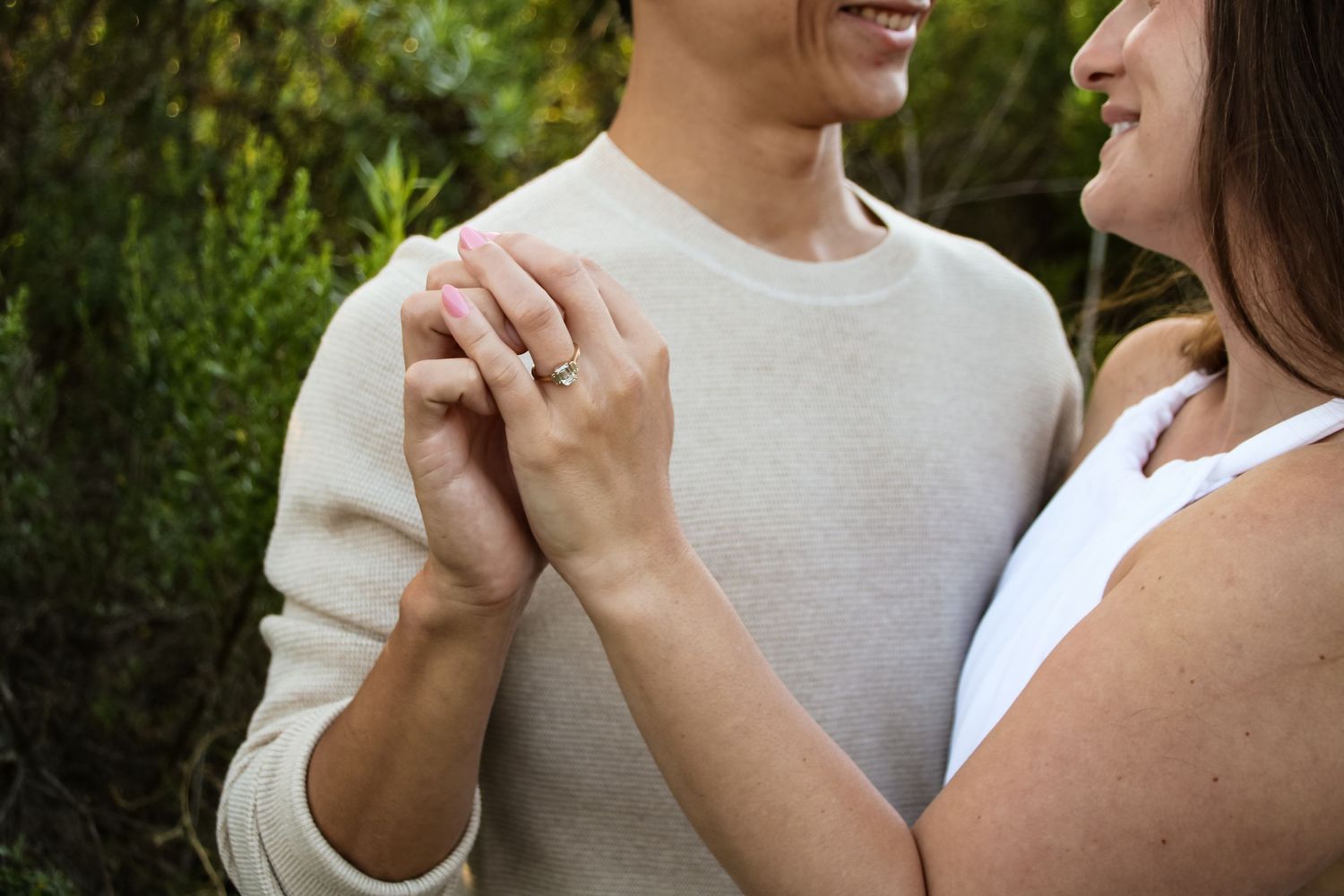 Tender moment between couple holding hands in natural lighting.