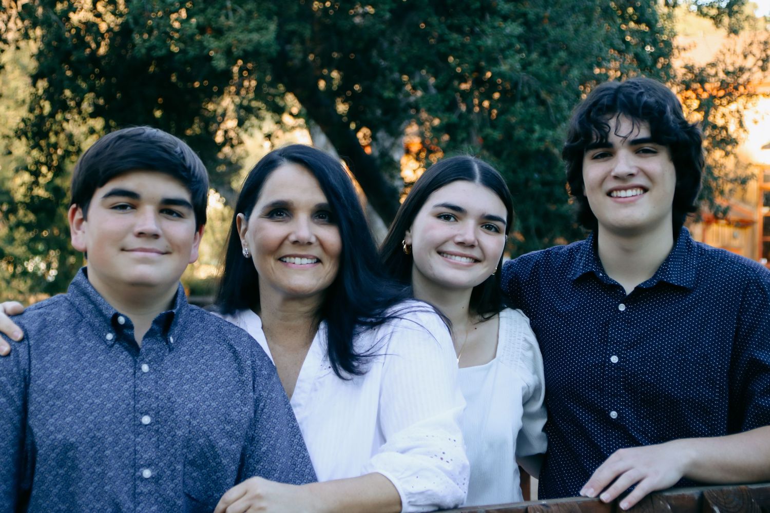 A group portrait outdoors with natural lighting and autumn trees in the background.