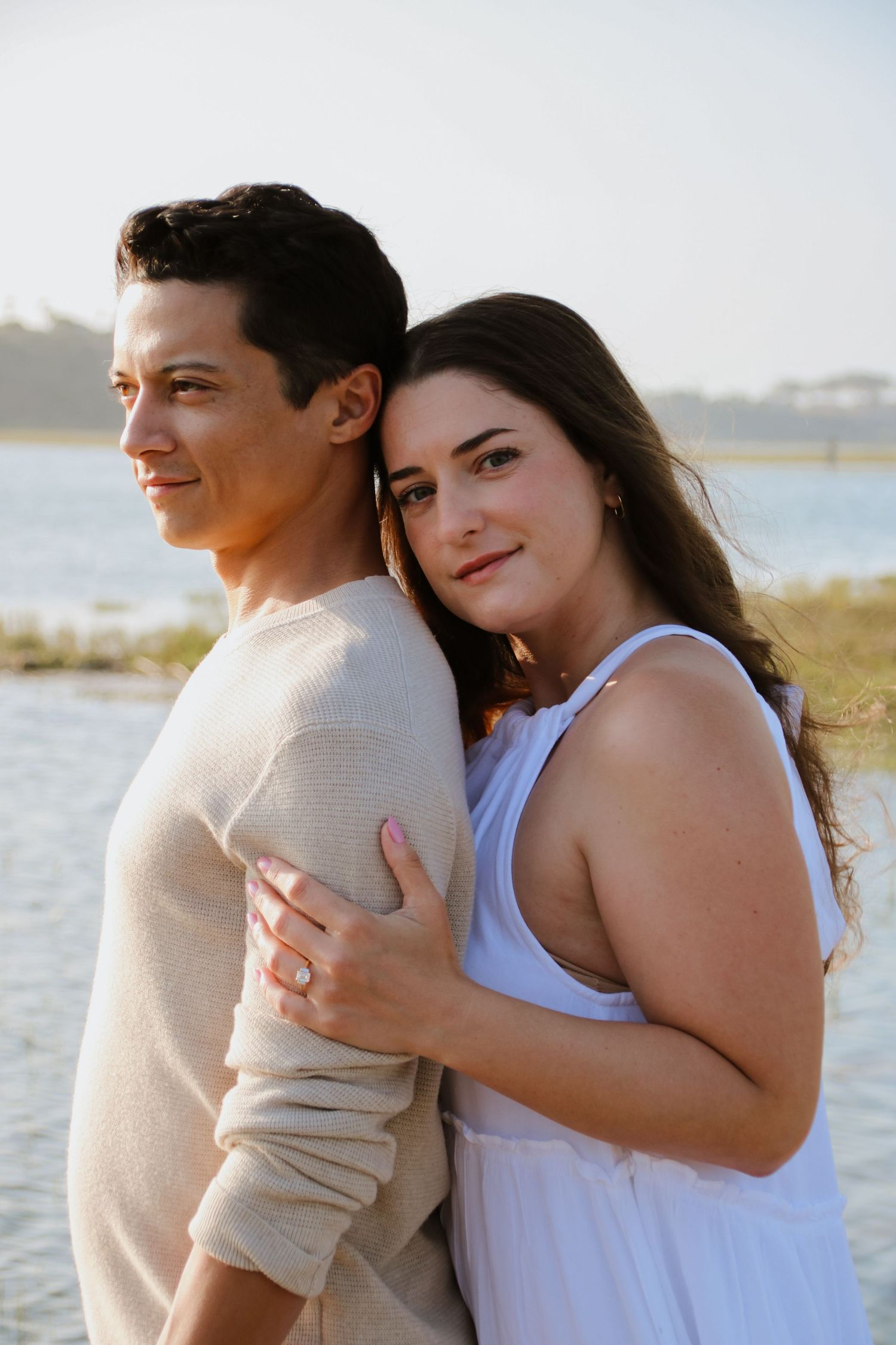 Loving couple sharing an intimate moment while standing near a scenic waterway.