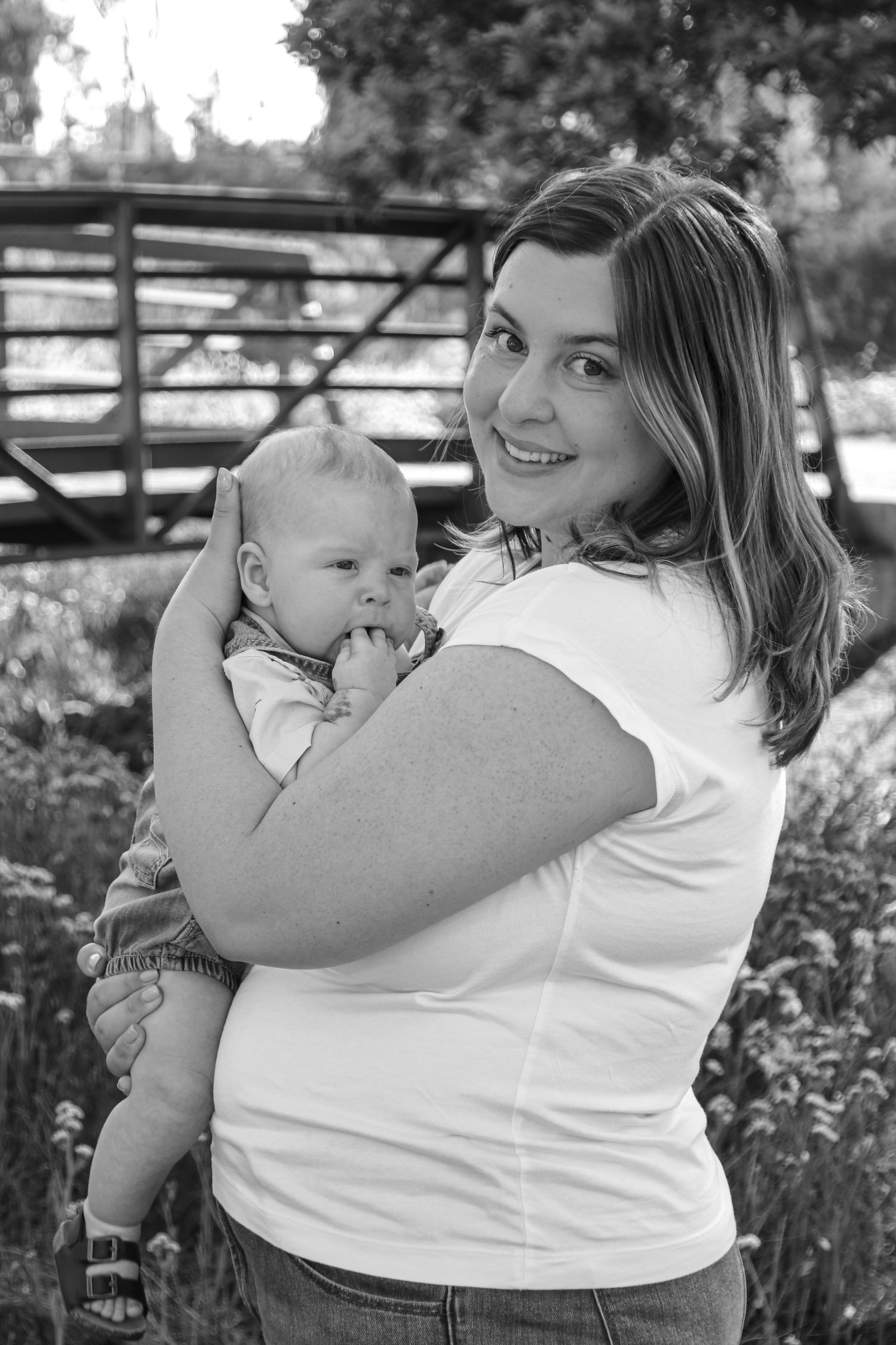 Black and white candid portrait of family sharing joyful moments outdoors.