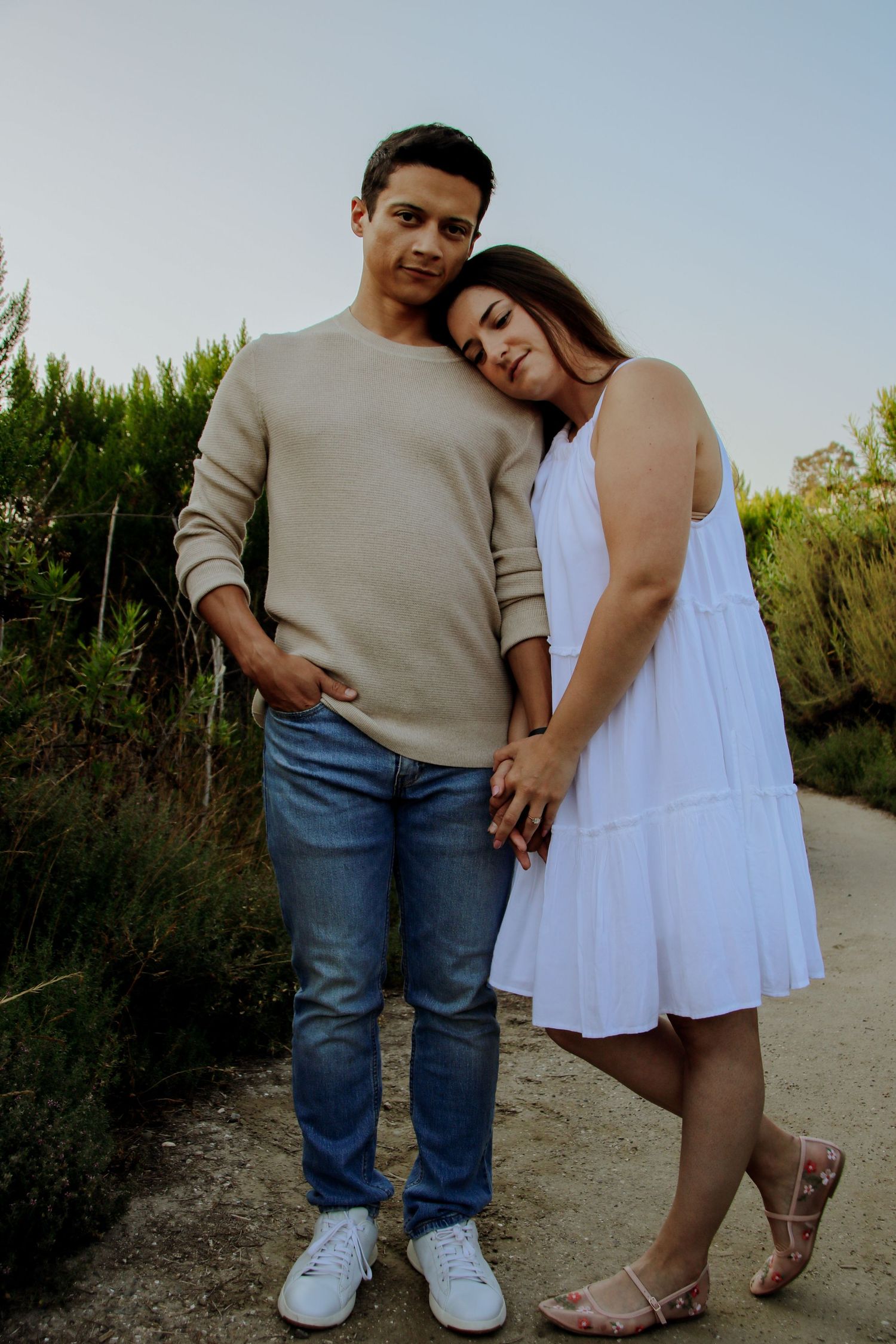 Couple in casual attire sharing intimate moment on nature path.