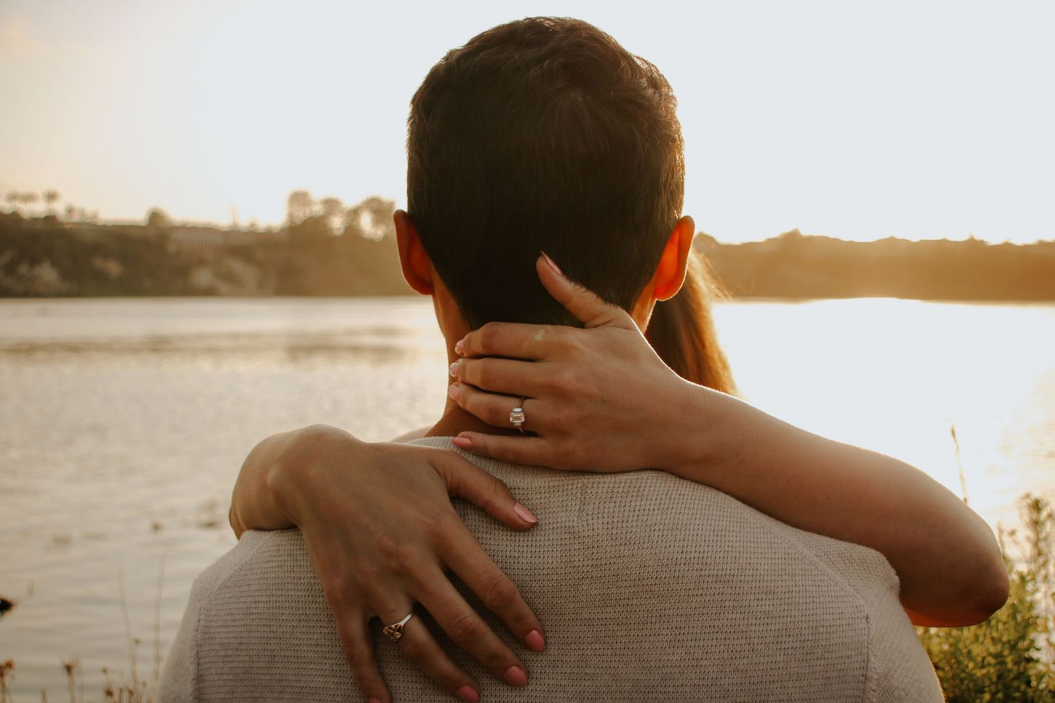 Sunset silhouette showing a tender embrace by the water.