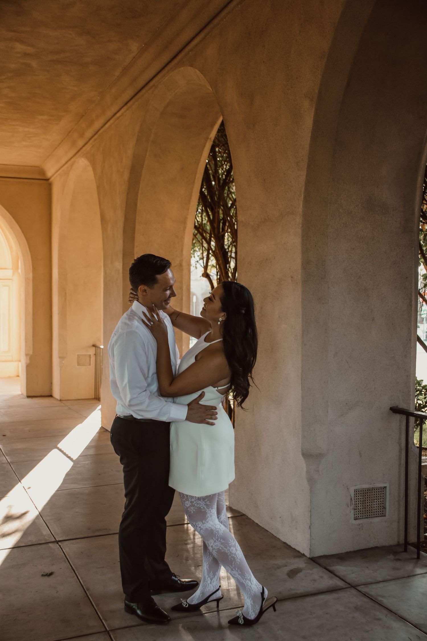 A sequence of romantic dance poses captured in an arched colonnade with natural lighting.