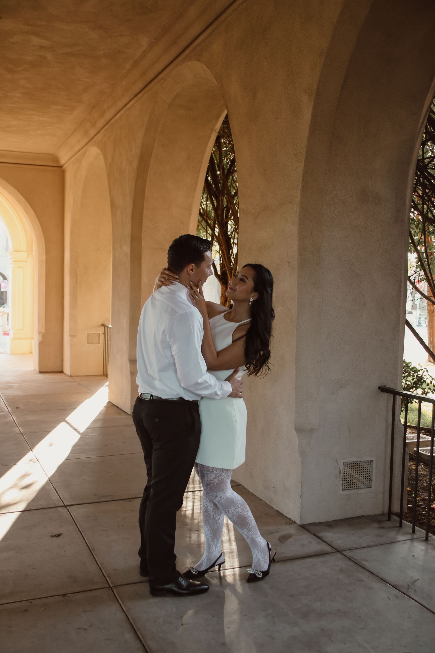 A series of photos capturing a couple's romantic interaction under white arched columns.
