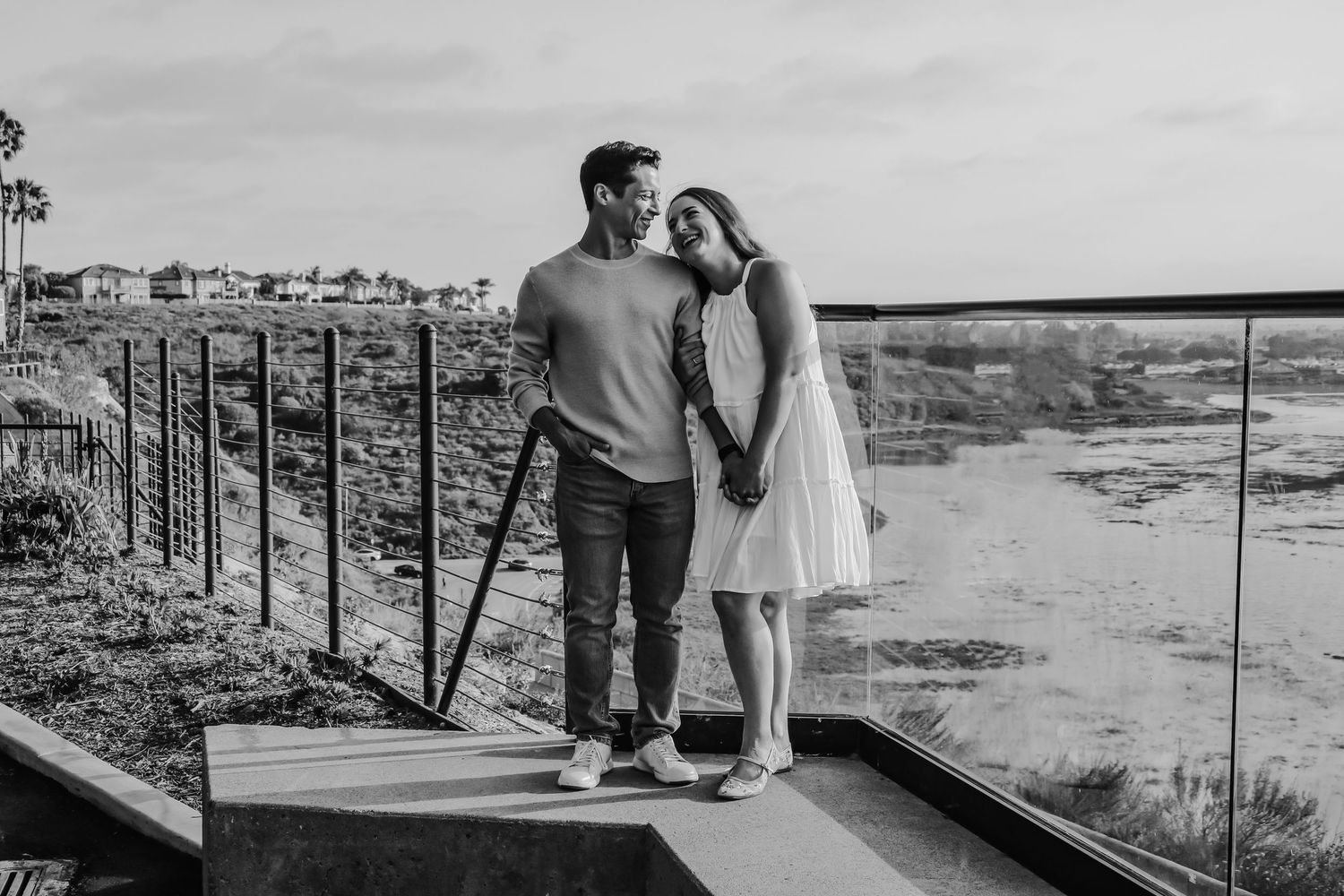 Romantic couple in casual attire sharing tender moments against scenic desert landscape at sunset.