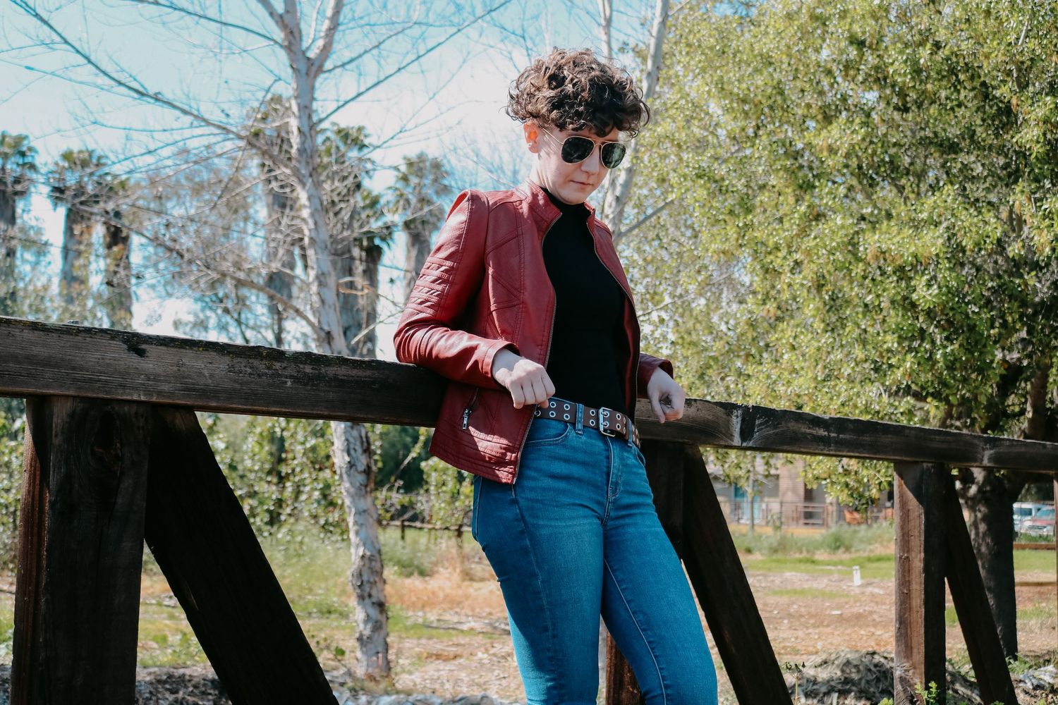 Trendy outdoor fashion photography featuring retro-inspired outfit against natural backdrop.
