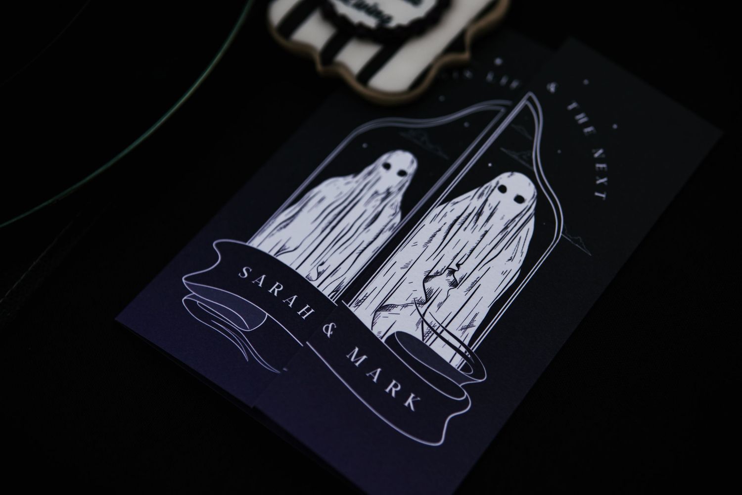Dark Halloween wedding invitation featuring two ghost illustrations with 