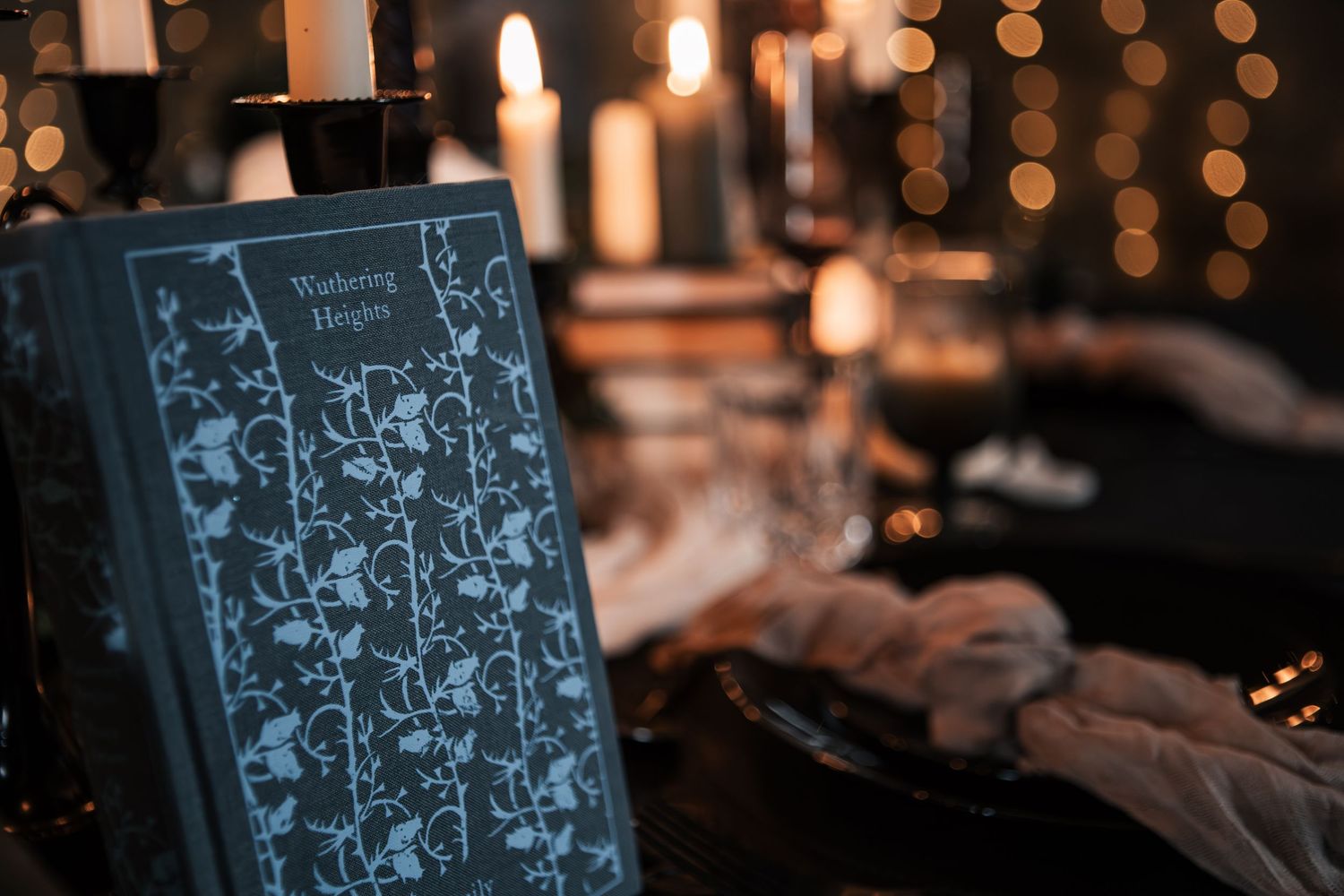 Wuthering Heights book displayed on a dark romantic candlelit wedding reception table.