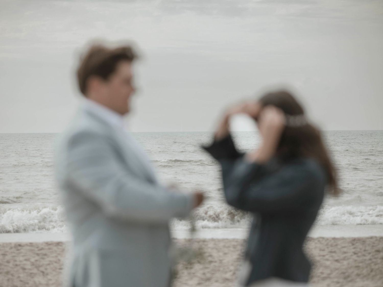 Blurred artistic photo of couple on beach during wedding photoshoot.