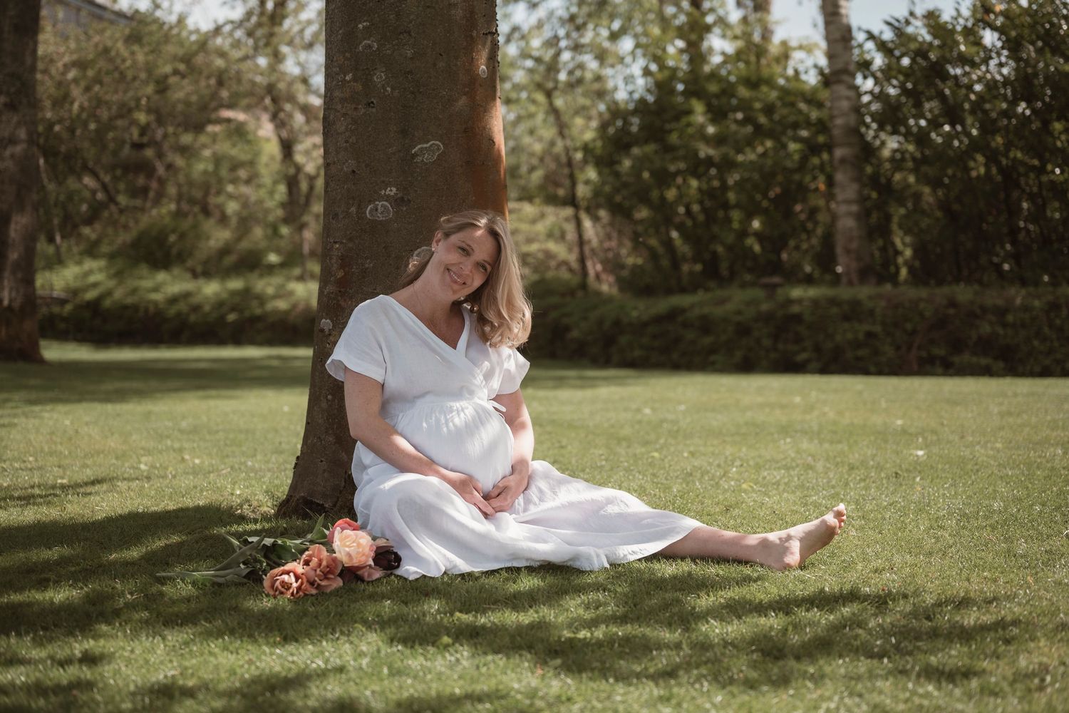 Gravid kvinde i lys kjole under gravidfotografering nær Herning