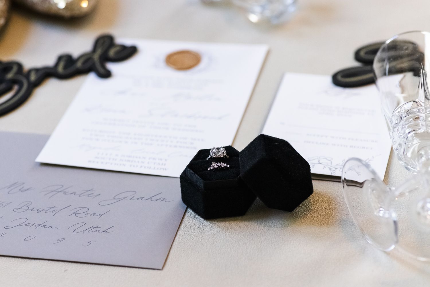 Wedding invitation suite with black velvet ring box and gray envelopes.