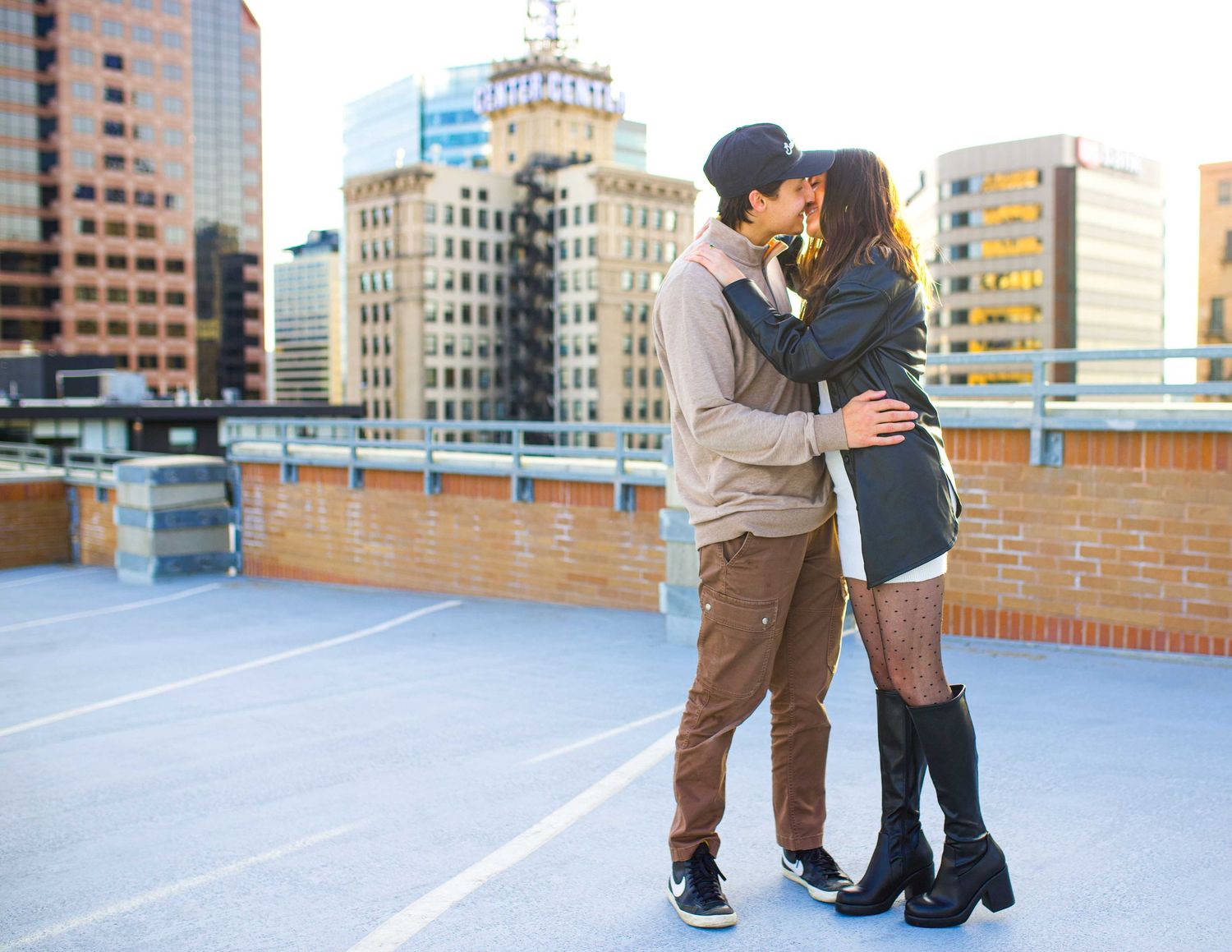 Romantic rooftop moment with city skyline backdrop.