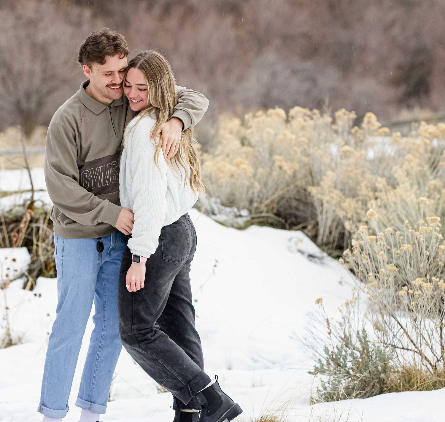 Romantic winter photoshoot showing tender moments between a couple in the snow.