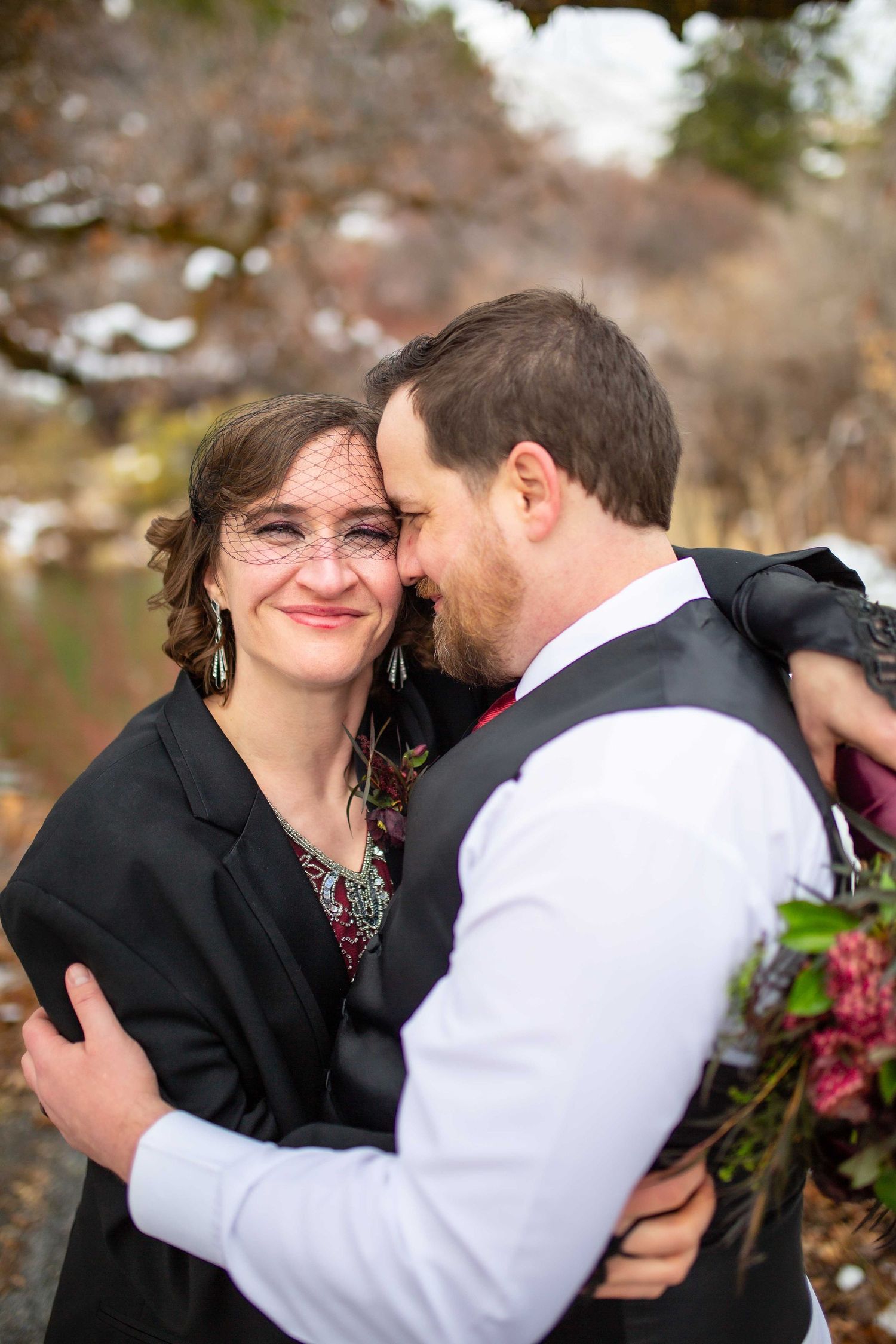 A sweet intimate moment captured during winter wedding portraits outdoors.