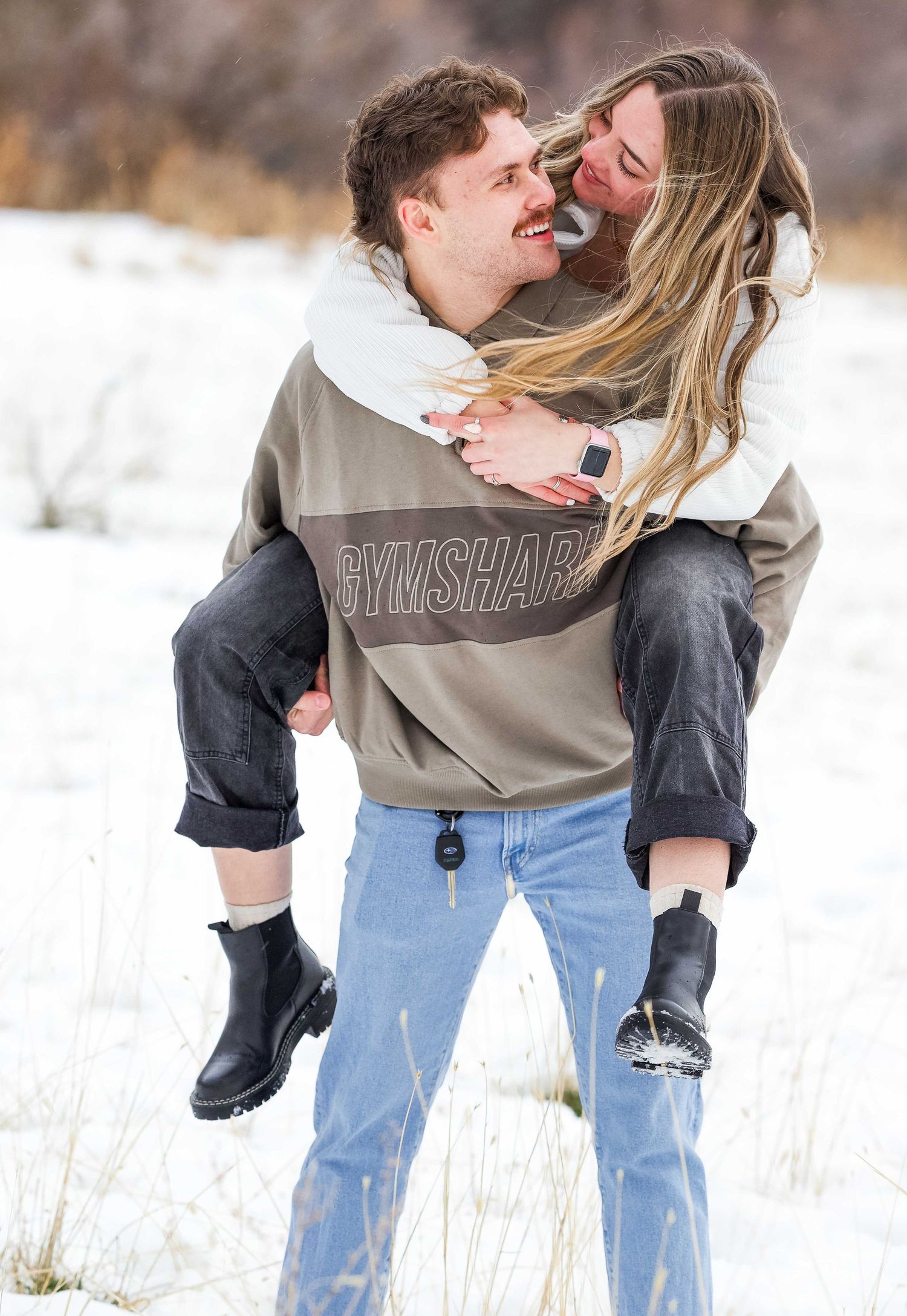 Romantic couple sharing intimate moments in a snowy winter field.