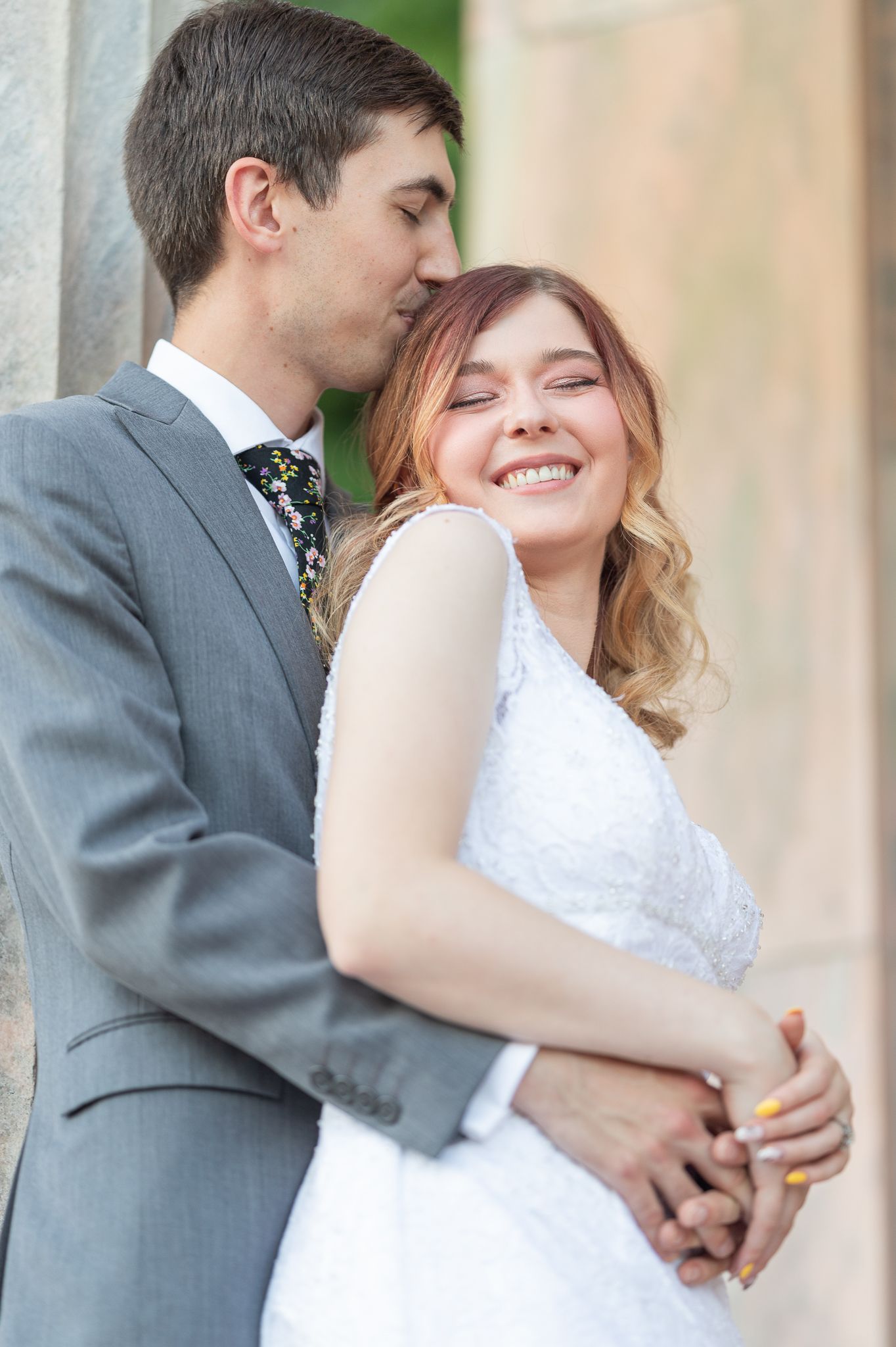 Couple in formal wear shares joyful embrace during outdoor photo session.