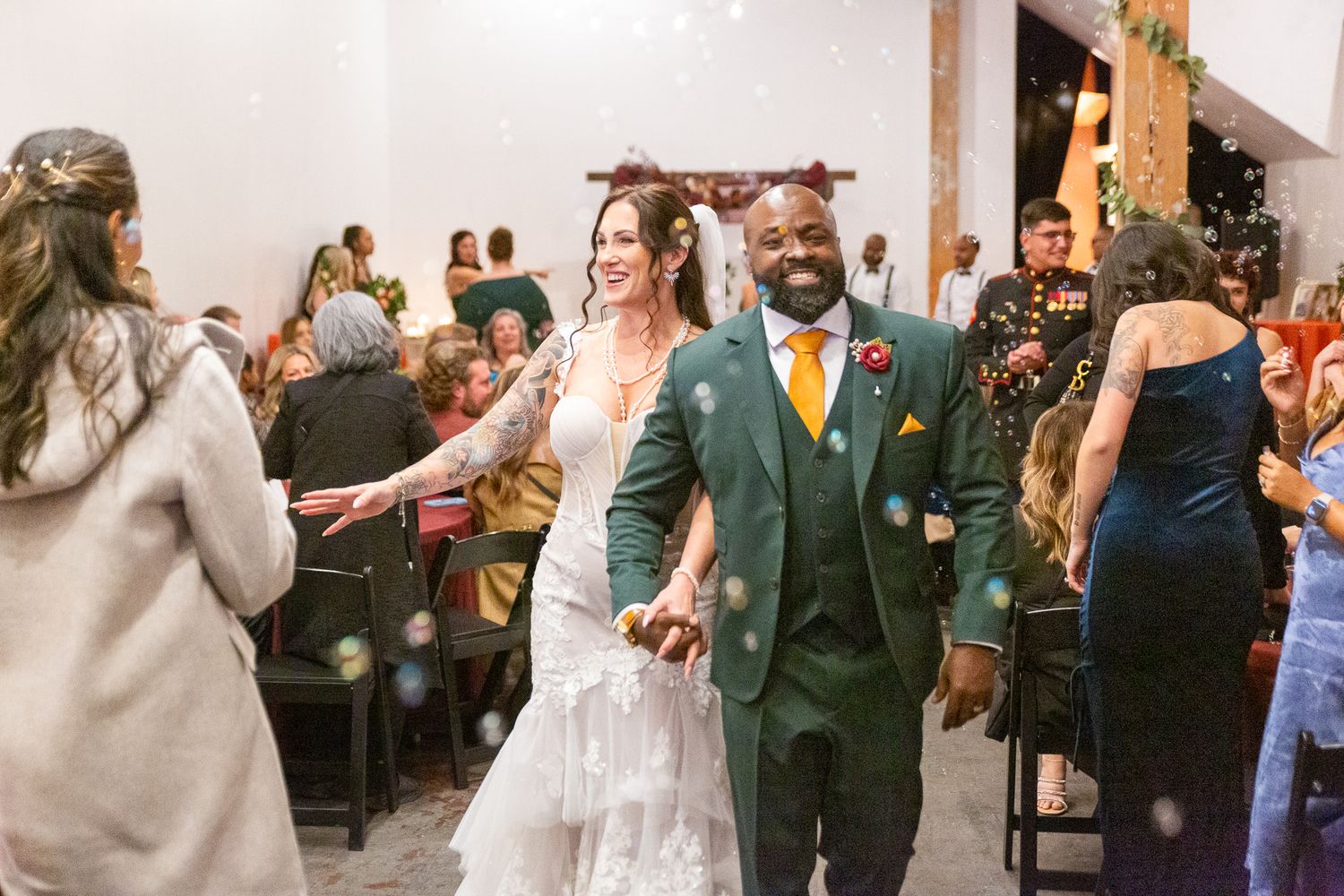 Wedding reception celebration with guests dancing in indoor venue.
