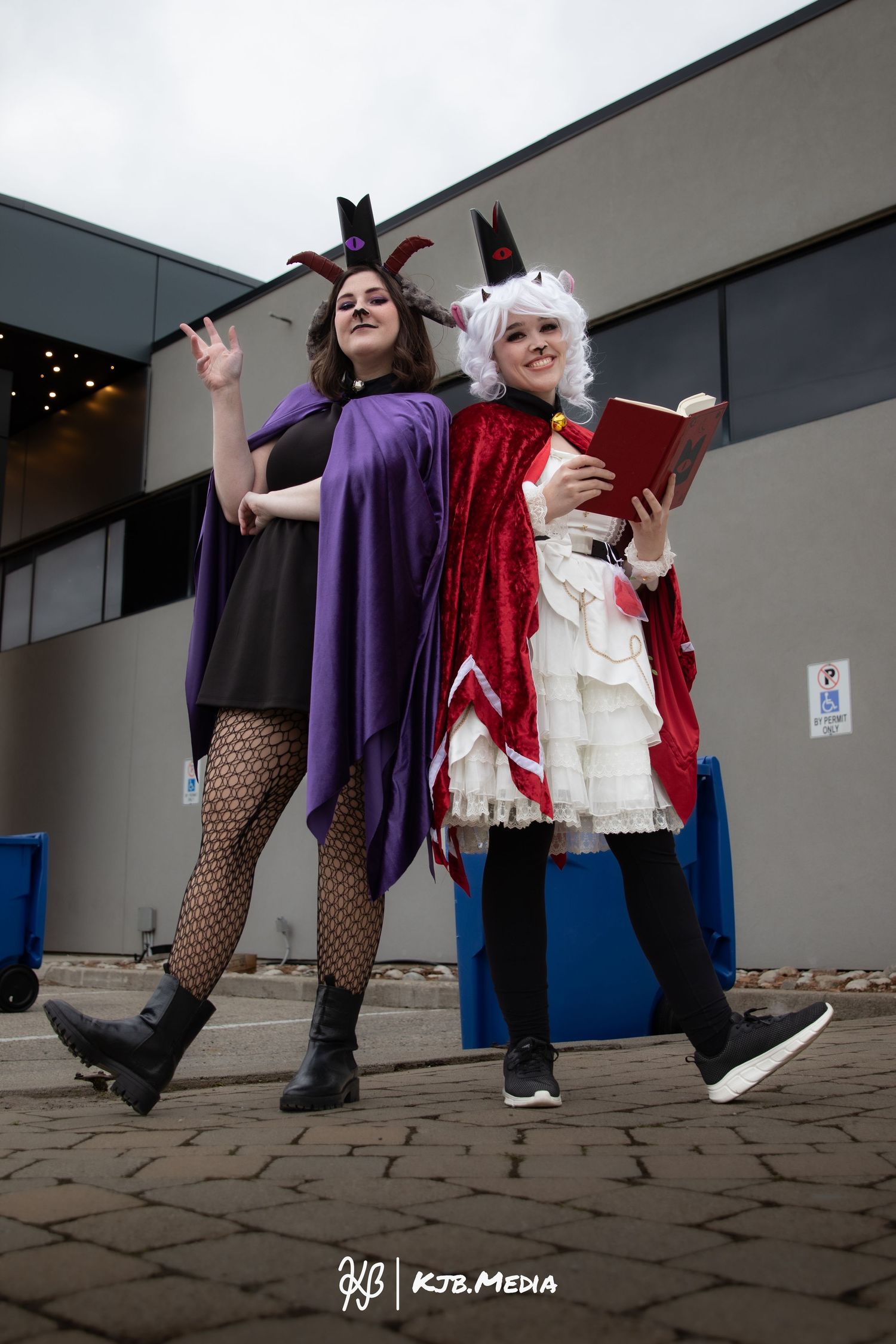 Two cosplayers in gothic-style costumes posing dramatically outdoors.