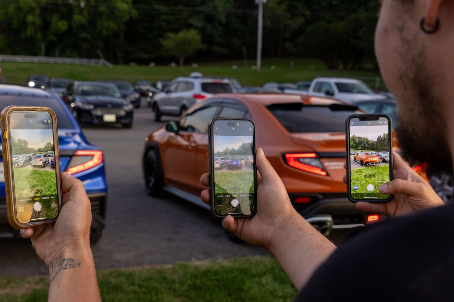 A person shows off a phone displaying the Pokemon Go mobile game against a street parking lot background.