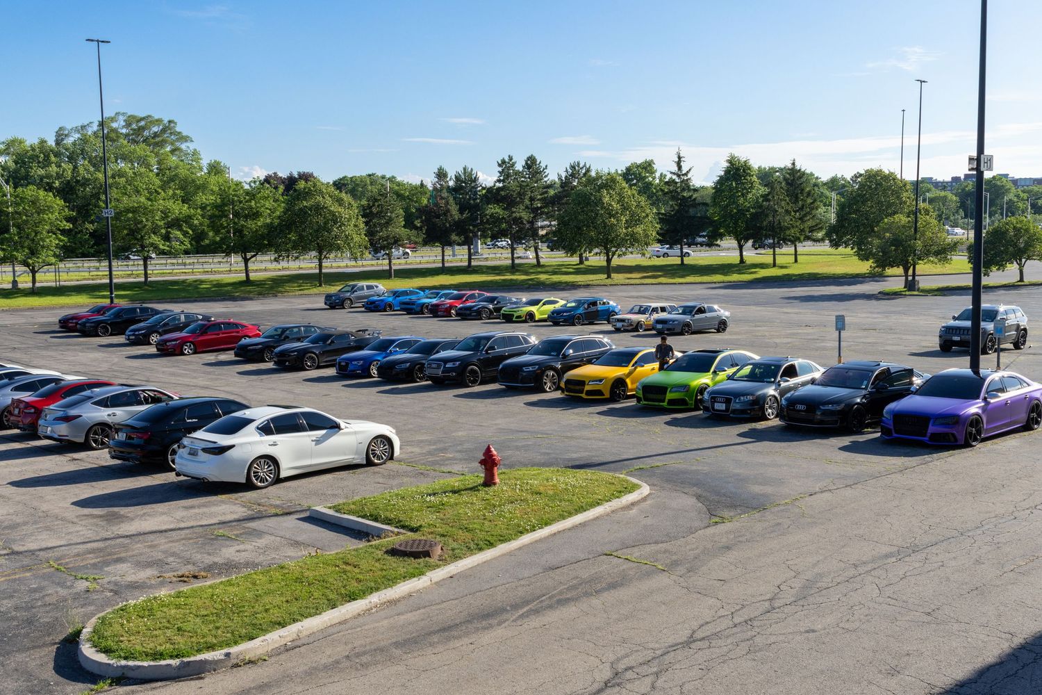 Panoramic view of a parking lot filled with luxury vehicles.