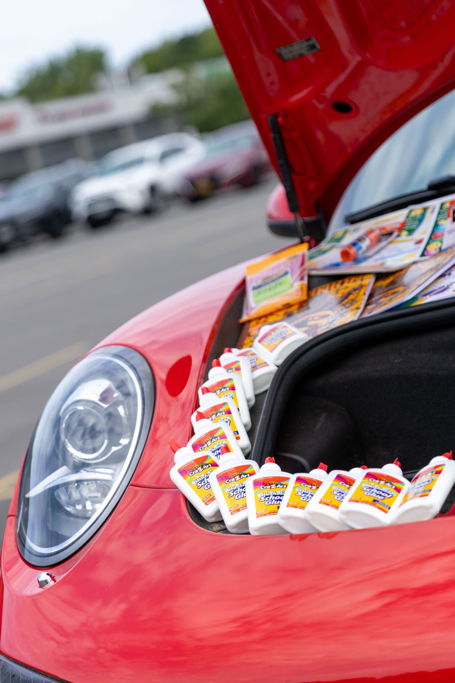 A close-up sequence of red car headlights with lottery tickets arranged on the hood showing progressive detail.