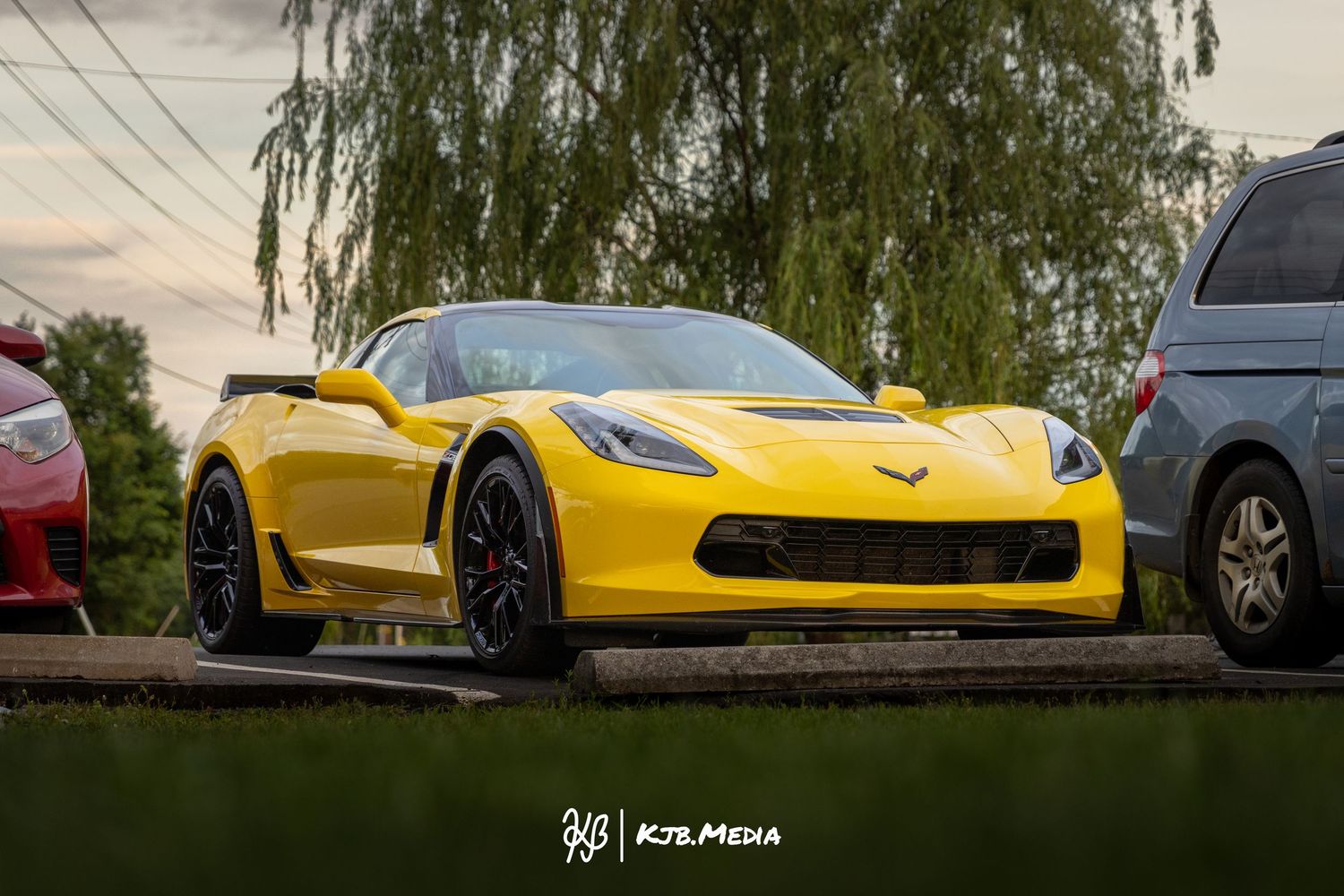 Bright yellow Chevrolet Corvette sports car parked among other vehicles.