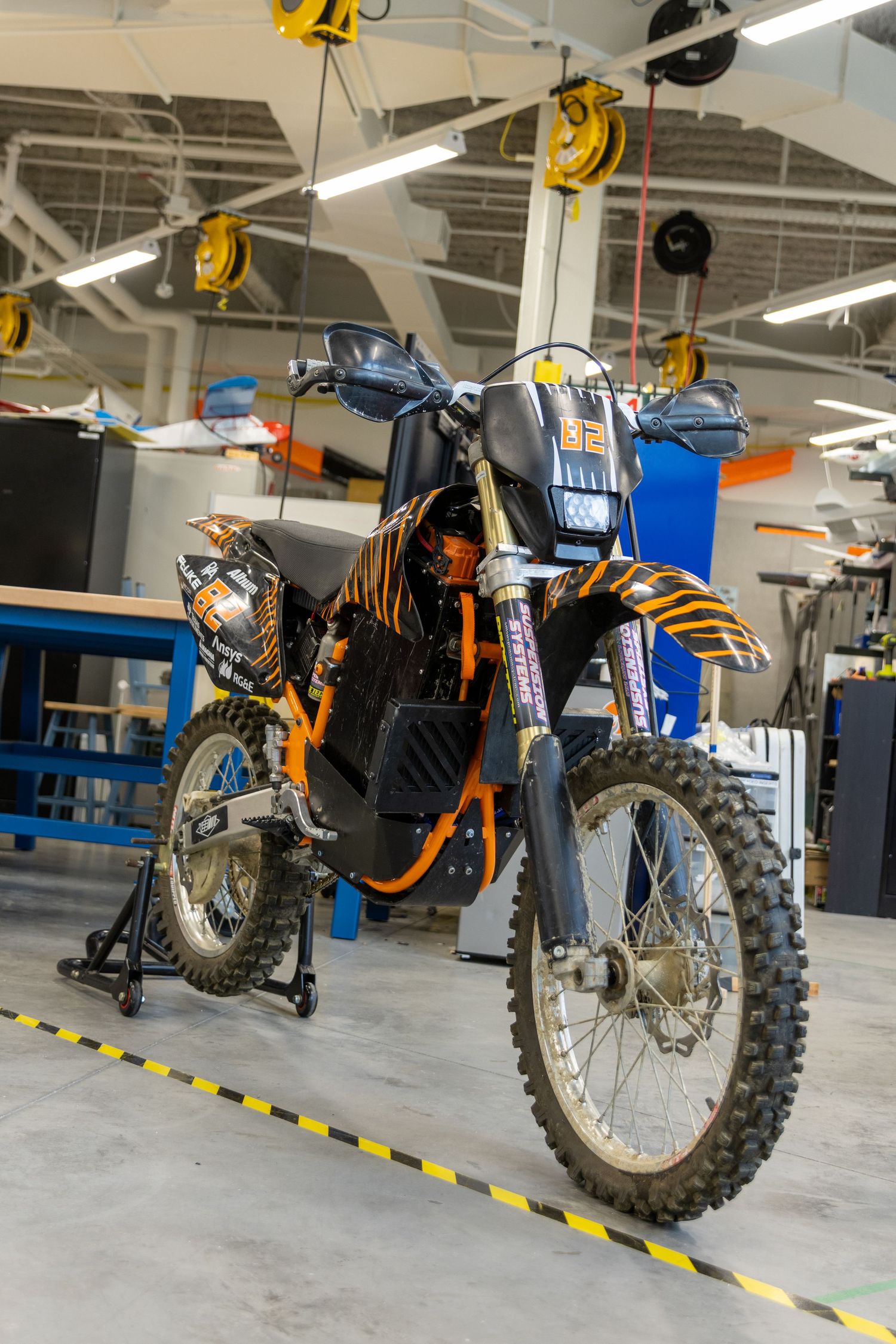 A sequence of five similar dirt bike images showing a motorcycle from different angles in a well-lit garage.