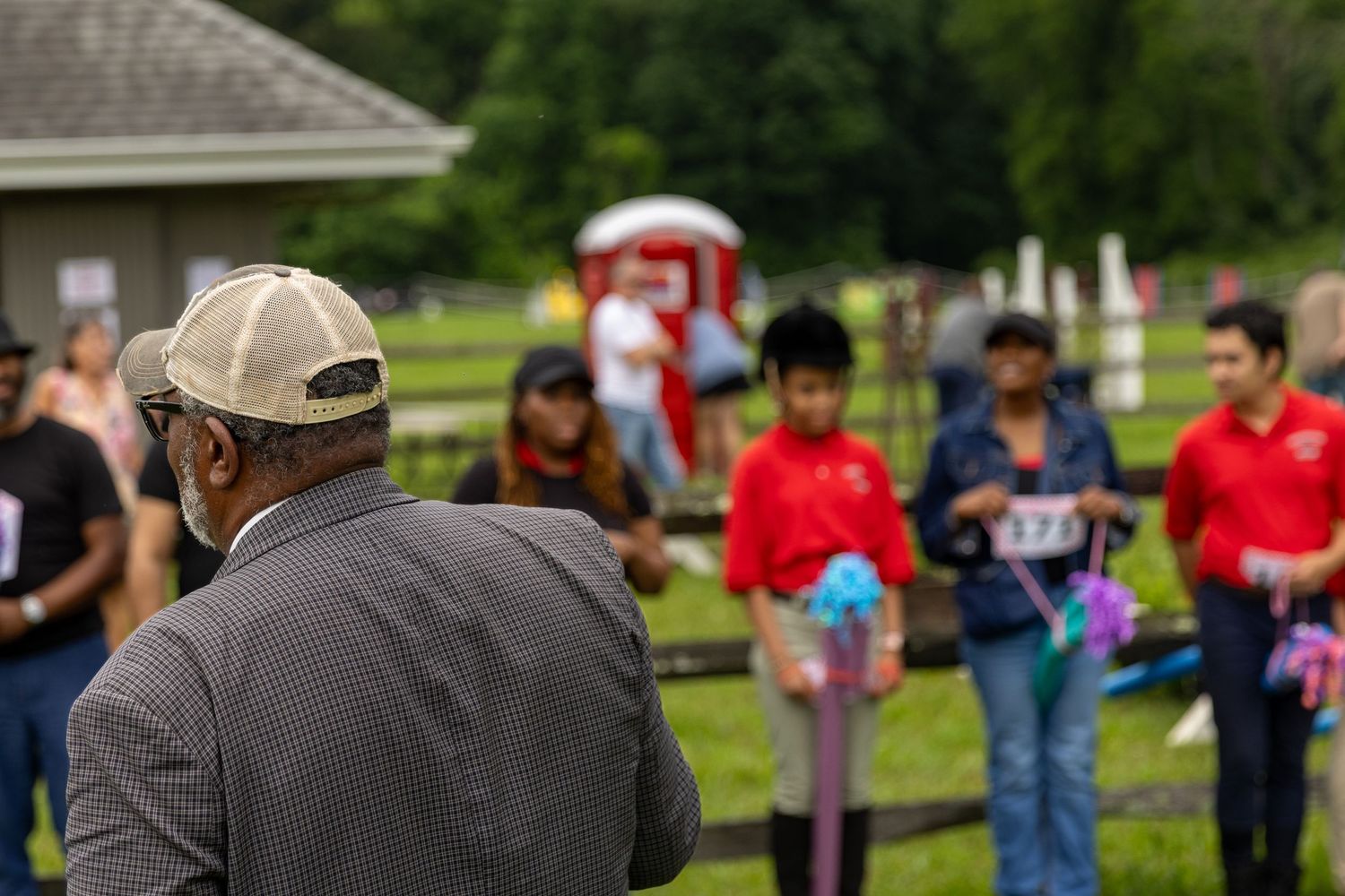 A crowd gathers at an outdoor event with spectators in casual attire.