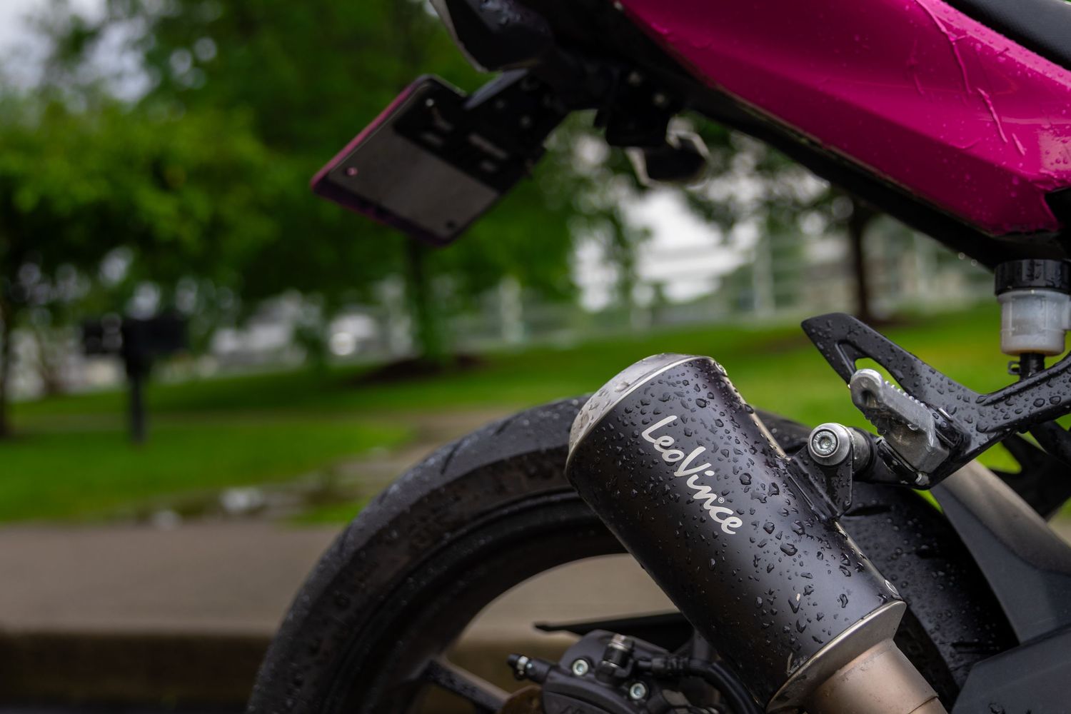 Close-up view of pink Kawasaki motorcycle showing fuel tank and handlebars.