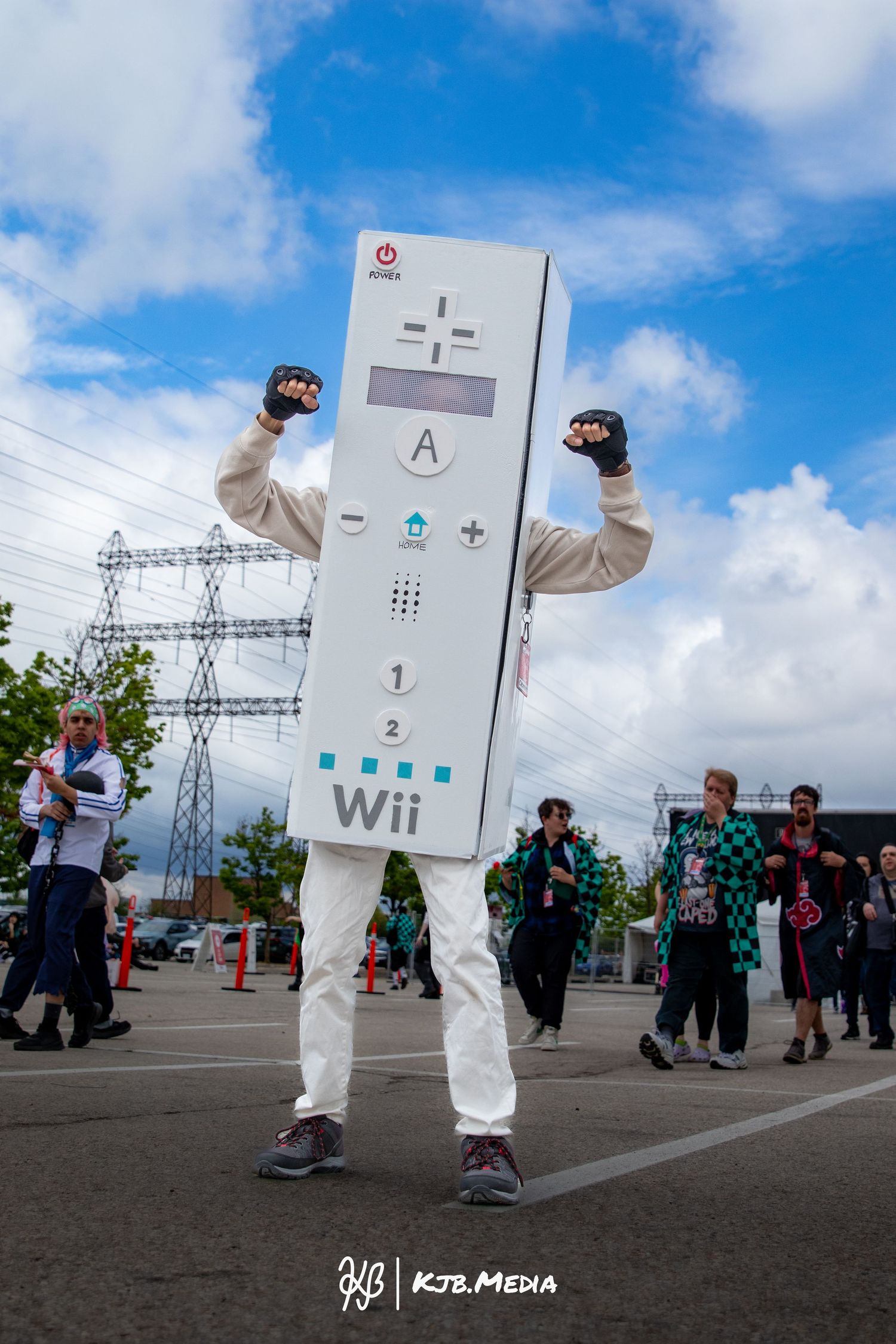 Creative cosplay of a life-sized Nintendo Wii remote controller at an outdoor event.
