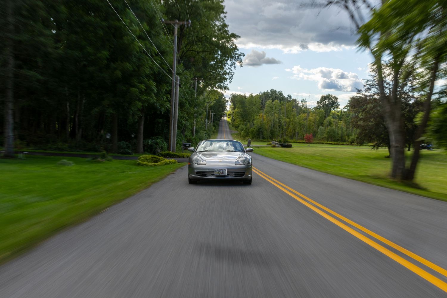 A series of similar rural road photos showing a winding tree-lined street with yellow dividing lines on a cloudy day.