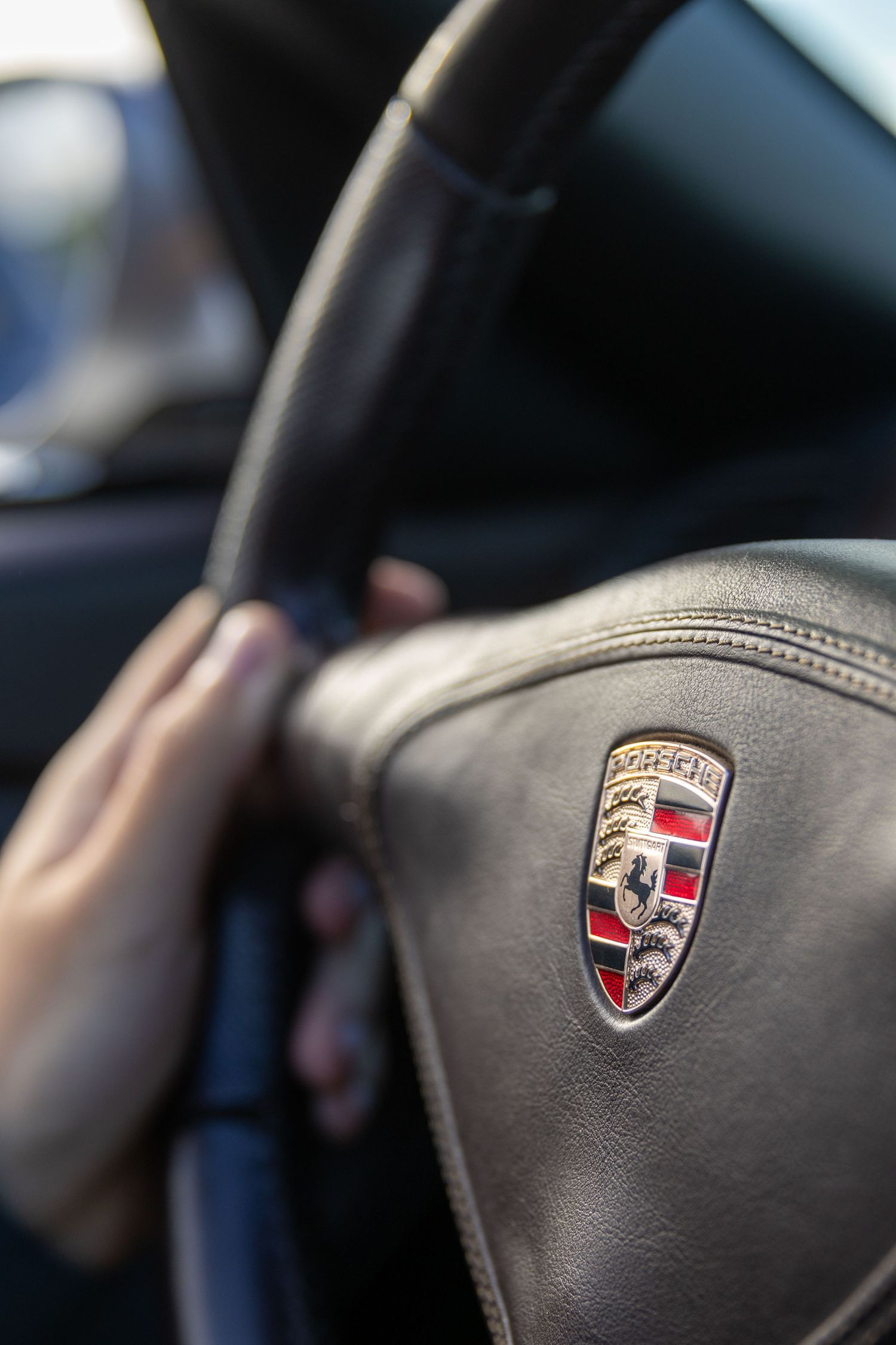 Close-up sequence showing Porsche logos on black leather interior surfaces at different angles and depths.